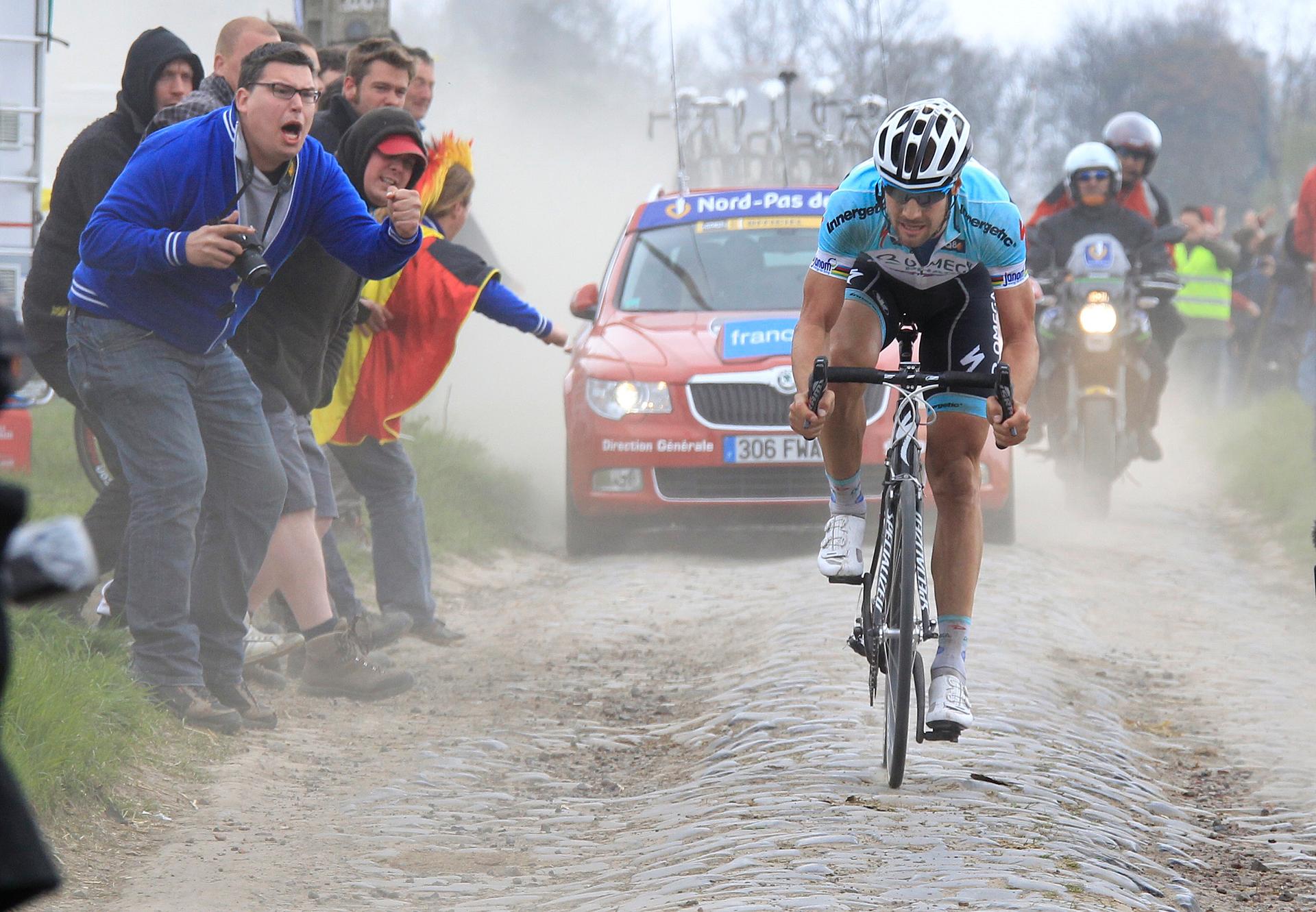 Belgium's Tom Boonen is cheered by supporters as he rides on a cobblestoned section of the Paris-Roubaix cycling classic in northern France, April 8, 2012.