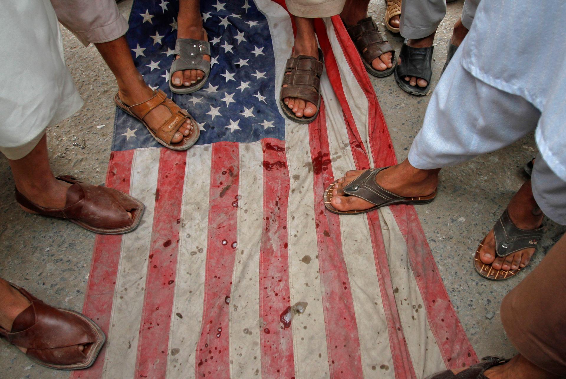 Men step on a U.S flag during an anti-American rally in Peshawar, Pakistan in April of last year.