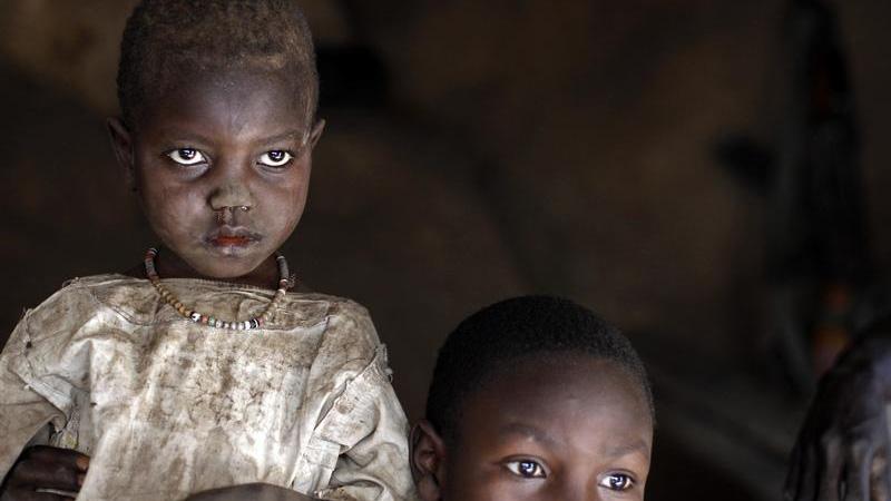 A girl and her brother shelter in a cave during an air raid in the Nuba mountains of Sudan in 2012.