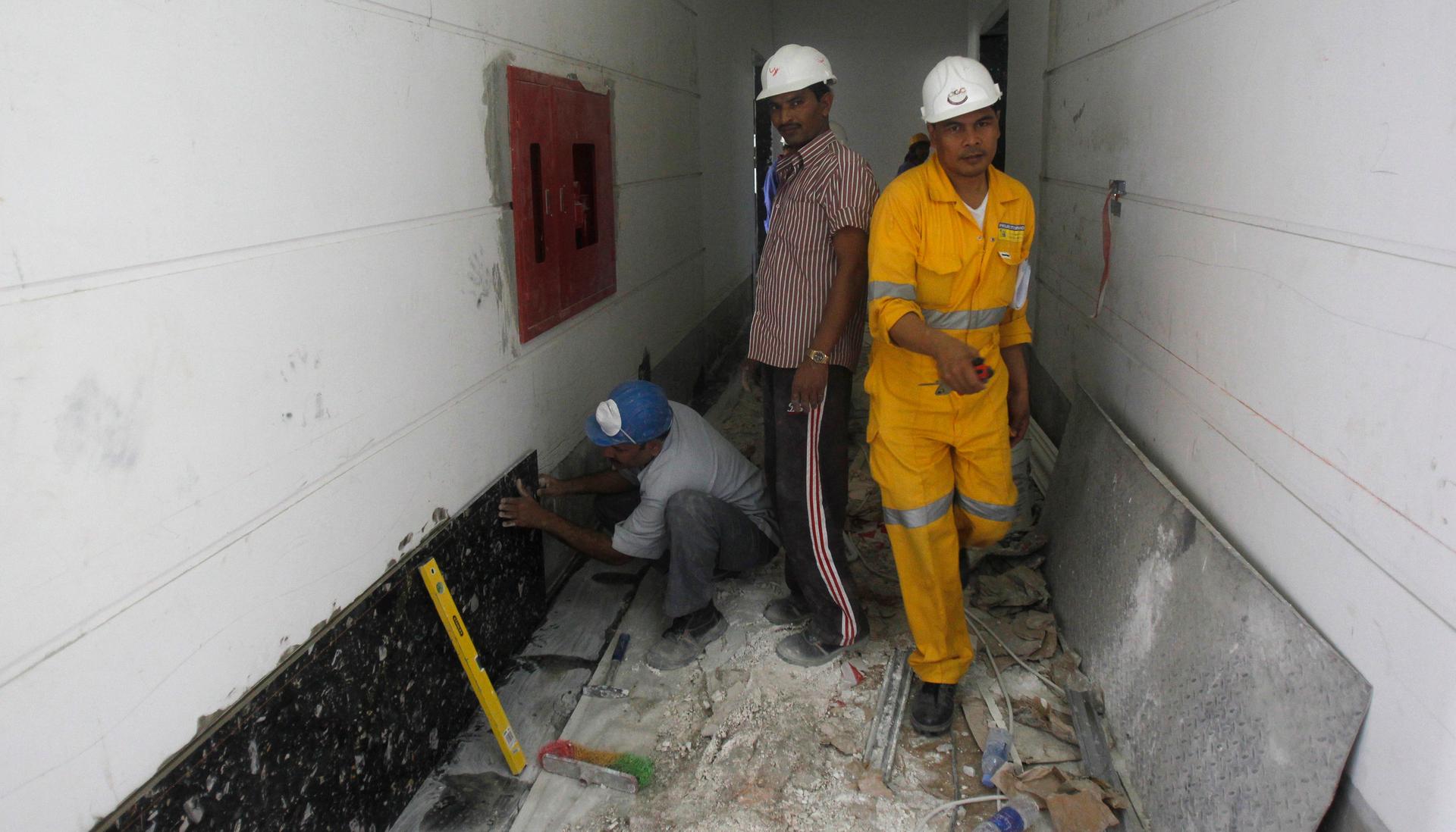 Laborers work at a construction site in Doha on June 18, 2012.