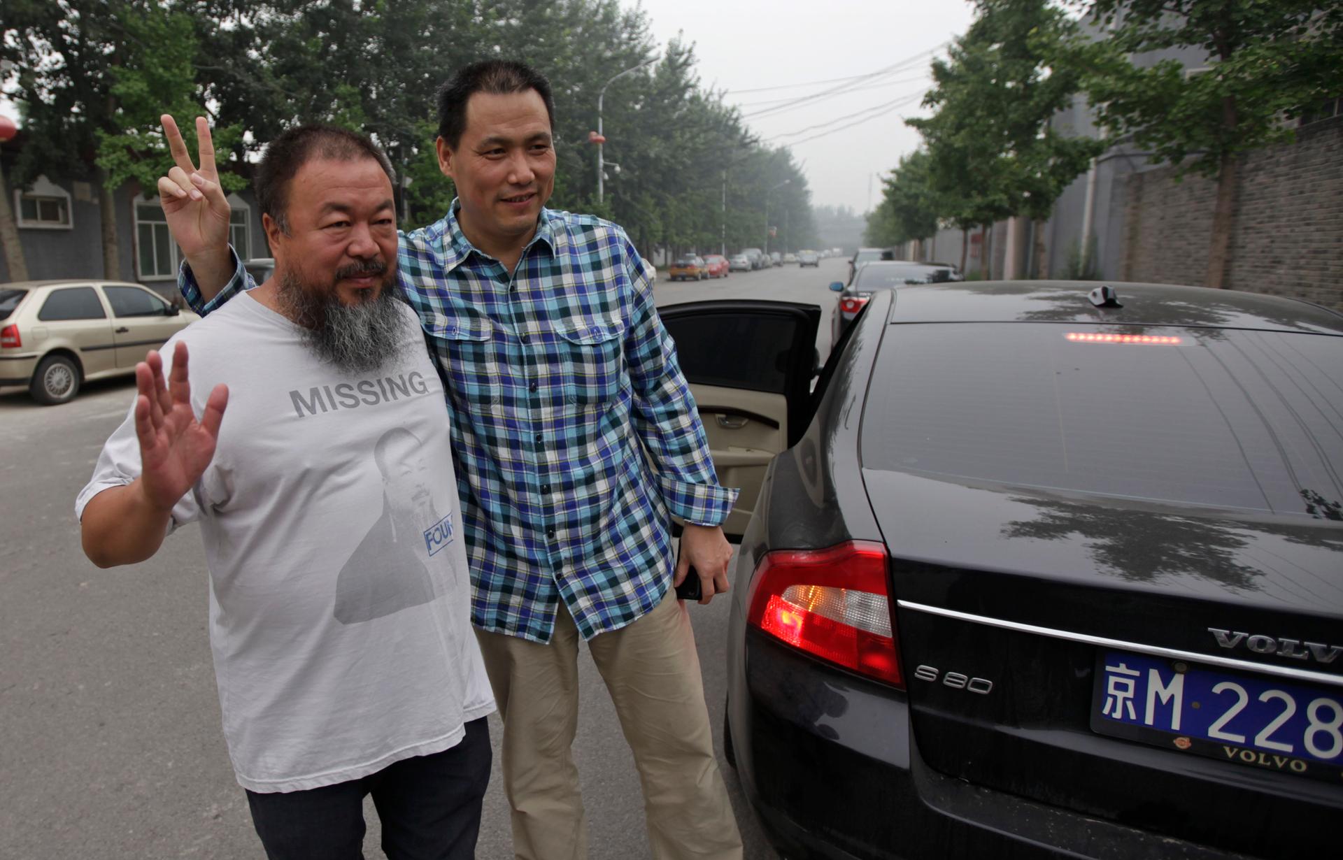 Chinese dissident artist Ai Weiwei, at left, poses outside his studio for a photograph with his lawyer, Pu Zhiqiang, in July 2012.