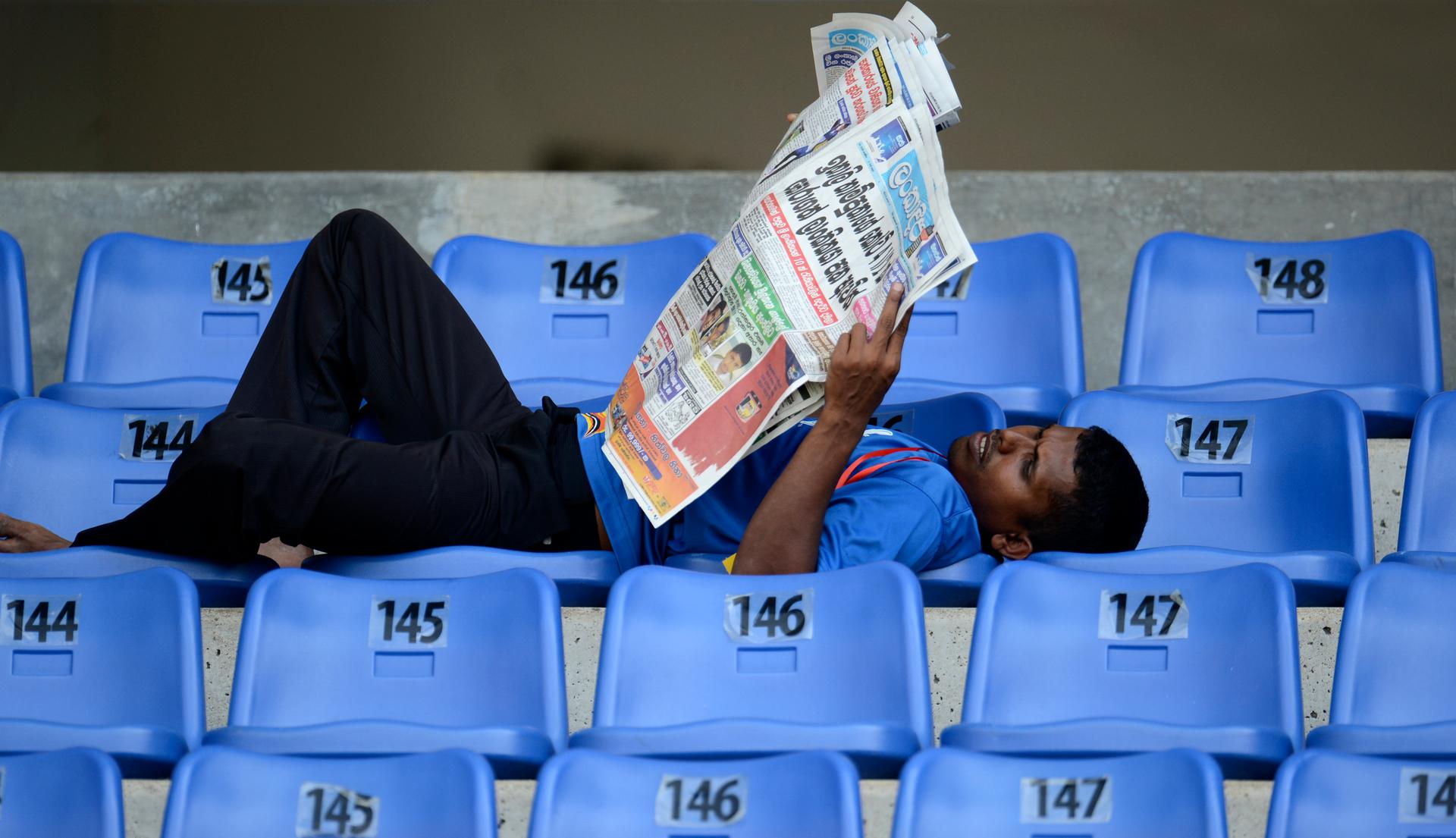 A Sri Lankan man reads the newspaper. People in Sri Lanka are most likely to read the paper in the mornings and evenings, the same times that disease-carrying mosquitoes come out to bite.