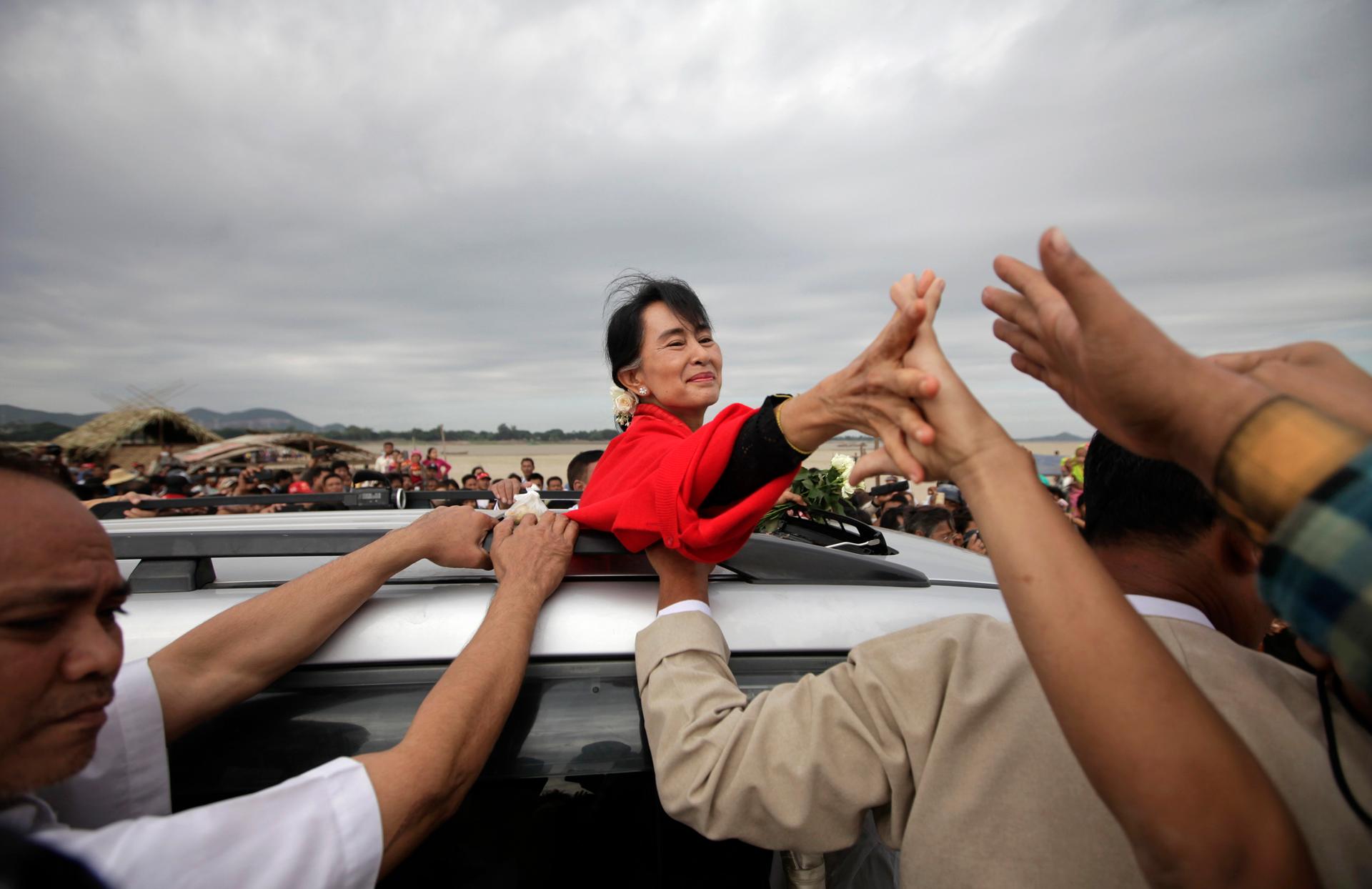 Myanmar pro-democracy leader Aung San Suu Kyi shakes hands with supporters after giving a speech in Monywa November 30, 2012.