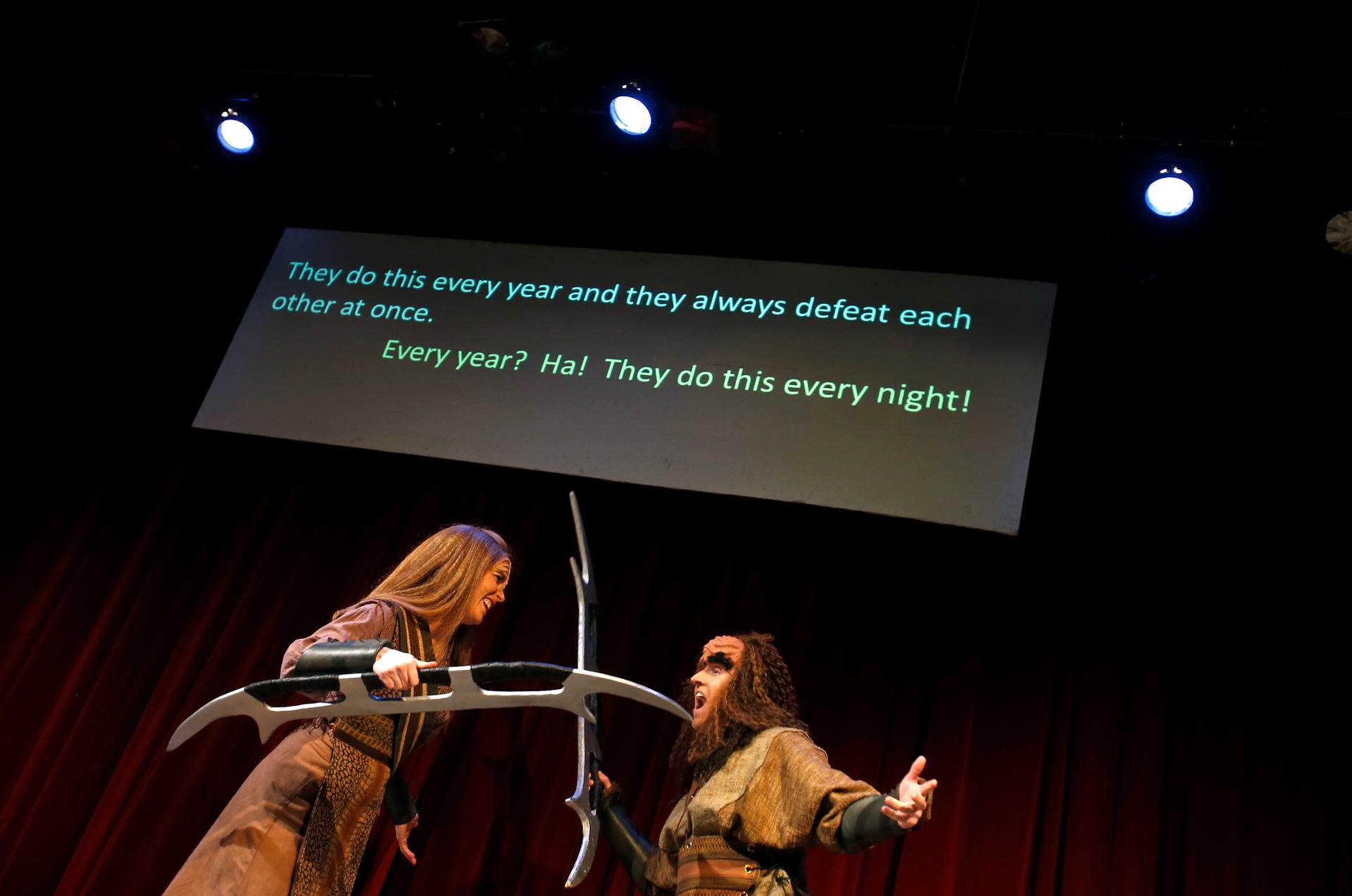 Performers Ali Kidder-Mostrom (L) and David Coupe perform a fight scene as a translation of their dialogue is projected on a screen during a performance of "A Klingon Christmas Carol" in Chicago, December 20, 2012