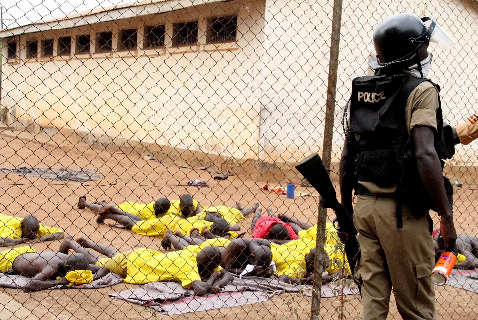 Prisoners are forced to lie on the ground after their prison riot was quelled at the Lira Central Prison in Northern Uganda February 13, 2013.