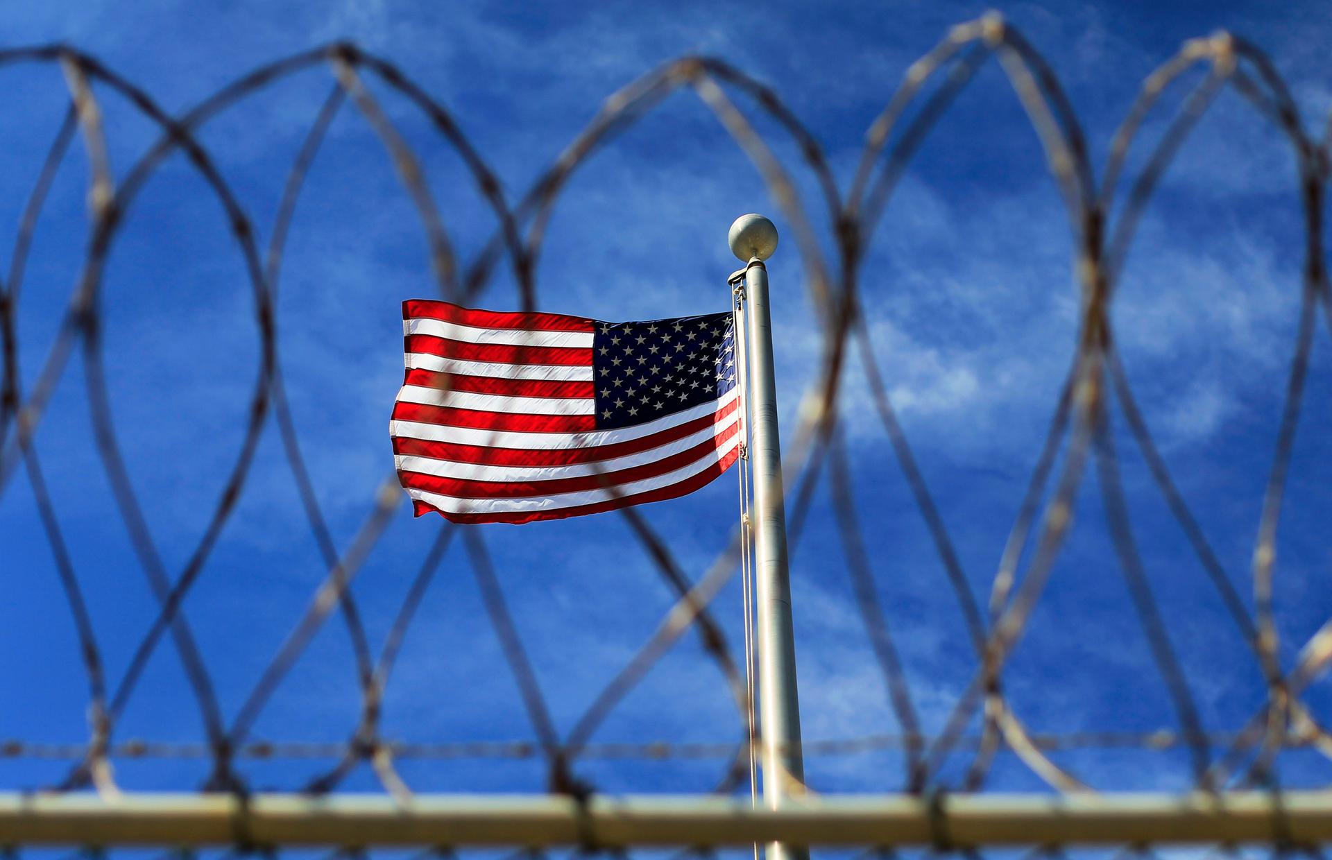 The U.S. flag flies over a prison used to house detainees at the U.S. Naval Base at Guantanamo Bay. The facility now holds around 150 prisoners who have been captured in Afghanistan and elsewhere since the September 11, 2001 attacks.