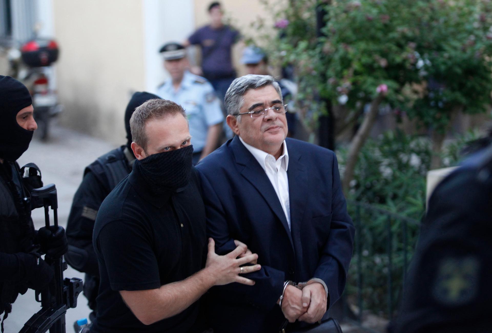 Far-right Golden Dawn party leader Nikos Mihaloliakos (R) is escorted by anti-terrorism police officers as he arrives at a courthouse in Athens September 28, 2013.