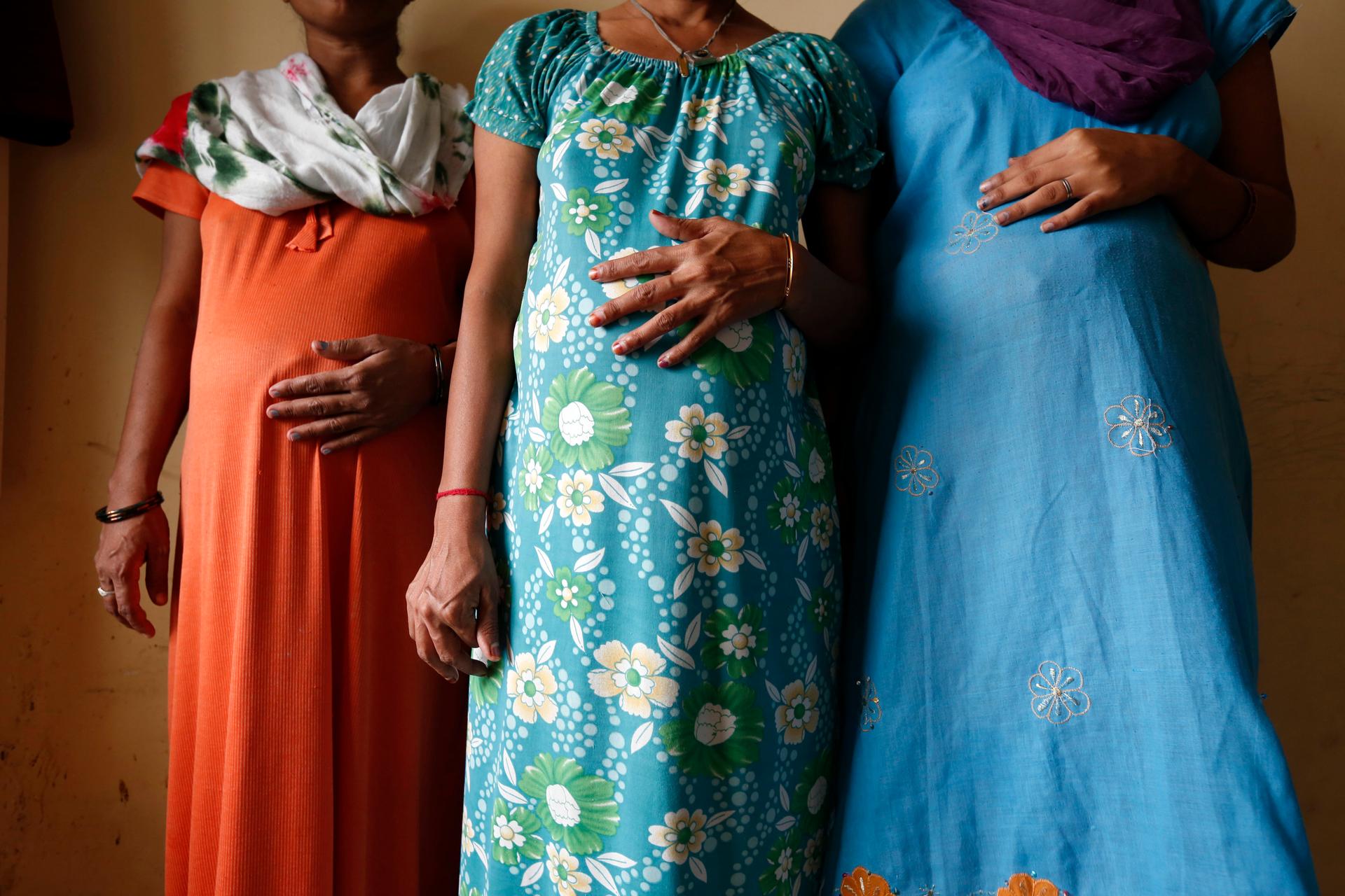 Surrogate mothers Daksha, 37, Renuka, 23, and Rajia, 39, left to right, pose for a photograph inside a temporary home for surrogates provided by Akanksha IVF centre in Anand town August 27, 2013.
