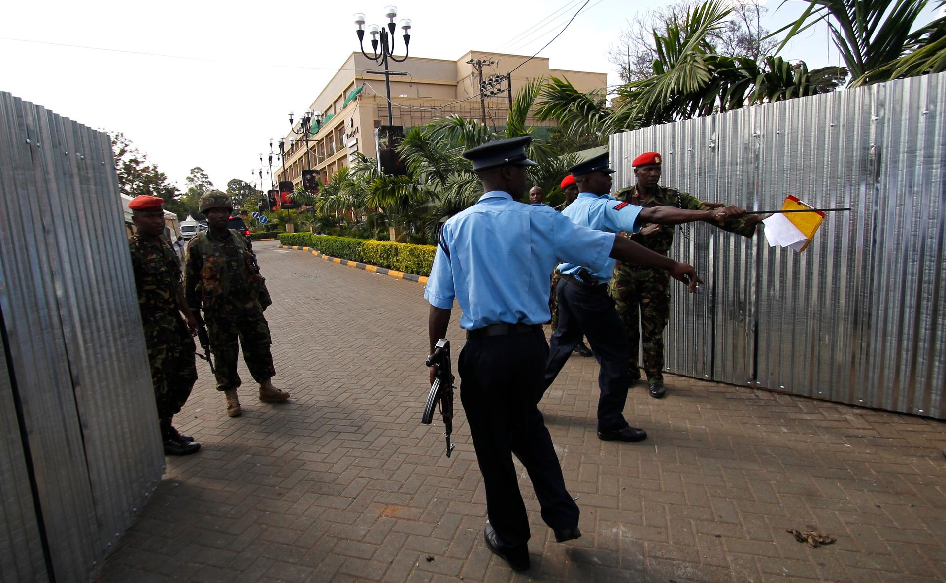Kenya police and military officers control the temporary entrance erected at the Westgate shopping mall following the recent attack in Kenya's capital Nairobi.