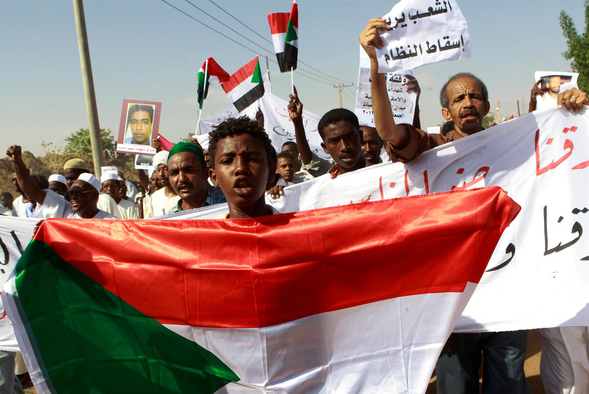 A man holds a Sudanese flag as he chants slogans against the government's deadly crackdown on people protesting against subsidy cuts late last month, during a demonstration after Friday prayers in north Khartoum