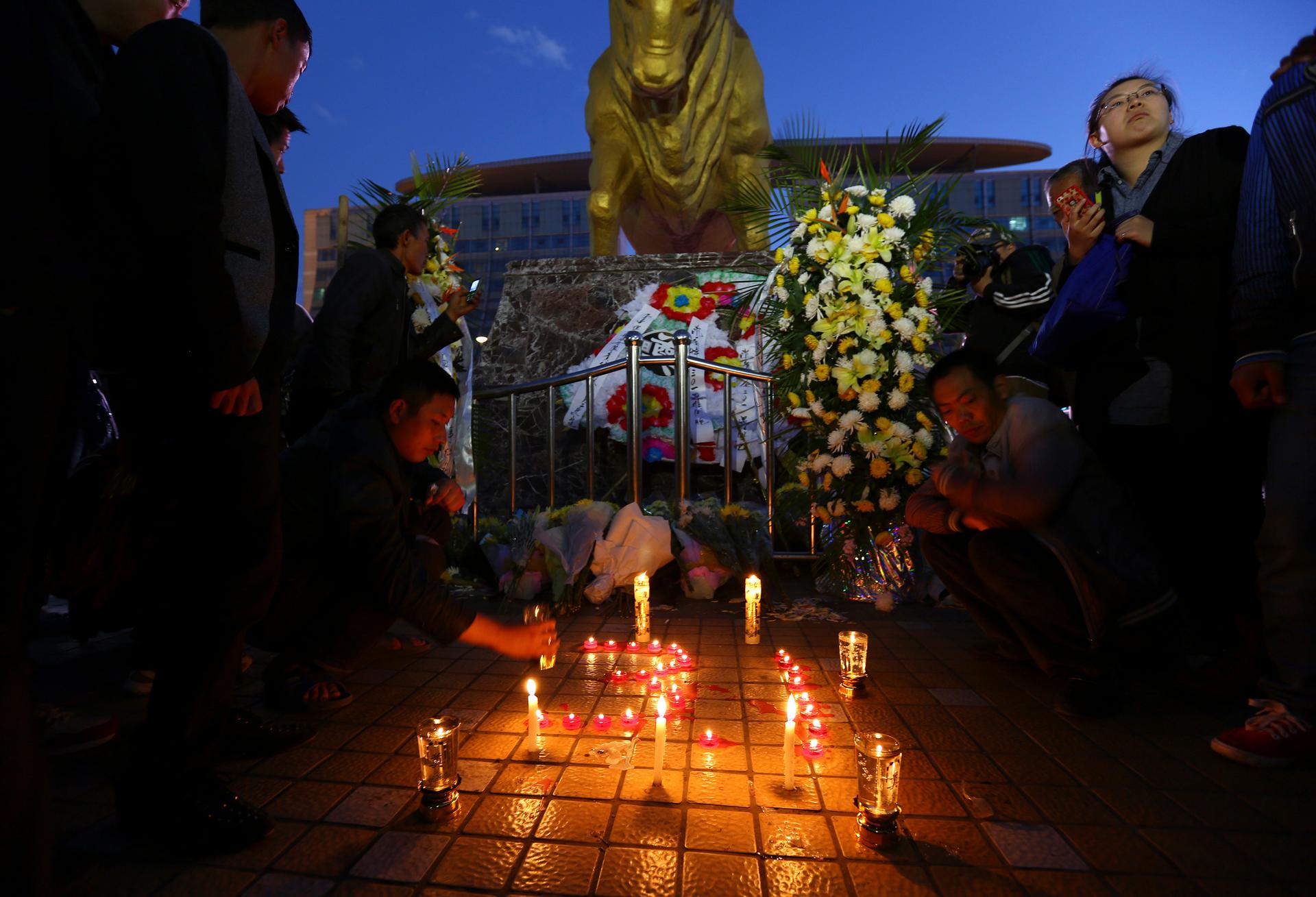 People light candles outside the Kunming railway station after a weekend knife attack that killed 29 people. 
