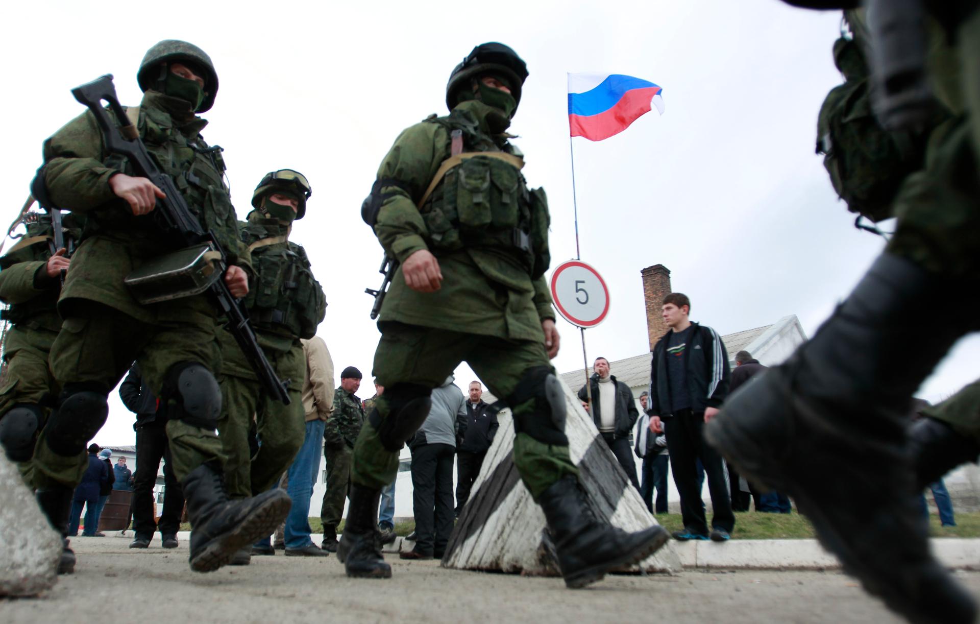 Military personnel, believed to be Russian servicemen, march outside the Crimean city of Simferopol, March 4, 2014. 