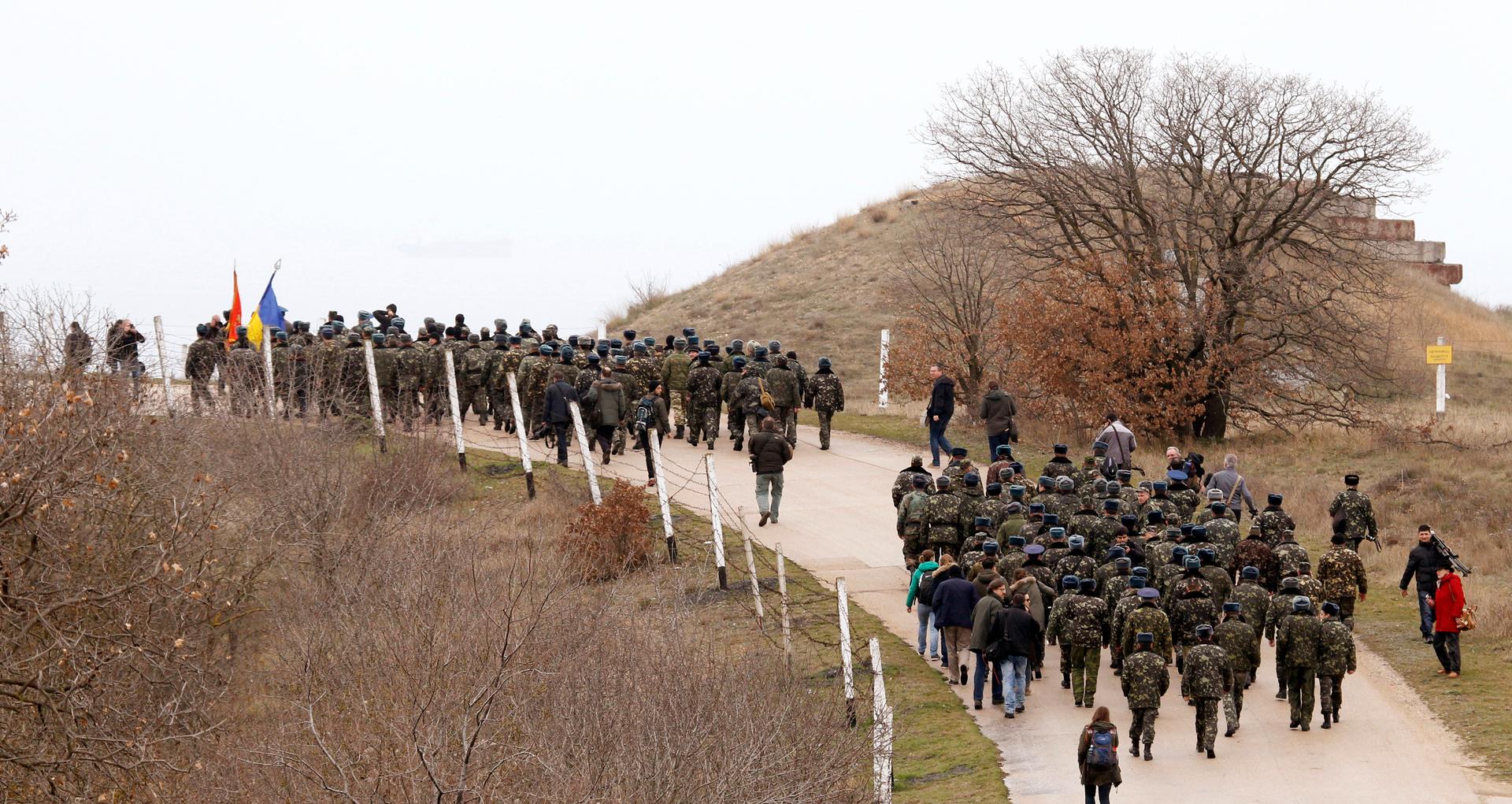 Ukrainian servicemen march away from the Belbek Sevastopol International Airport in the Crimea region on March 4, 2014. A column of unarmed Ukrainian servicemen arrived at the base for negotiations with Russian troops on Tuesday, local media reported. The