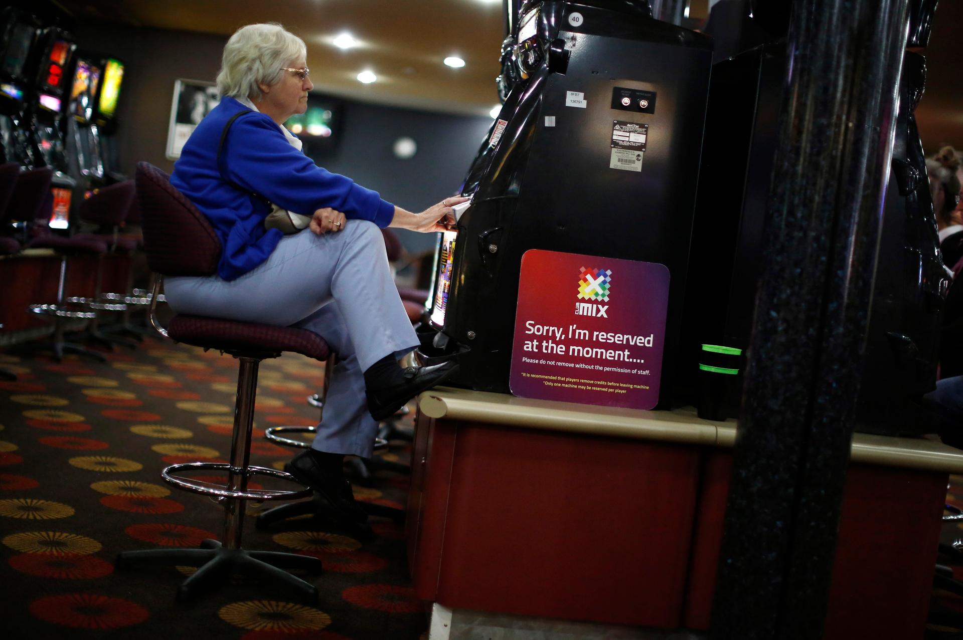 A visitor to the Shell Club, a sports and social venue, plays a slot machine near the Shell Oil refinery in Geelong, Australia.
