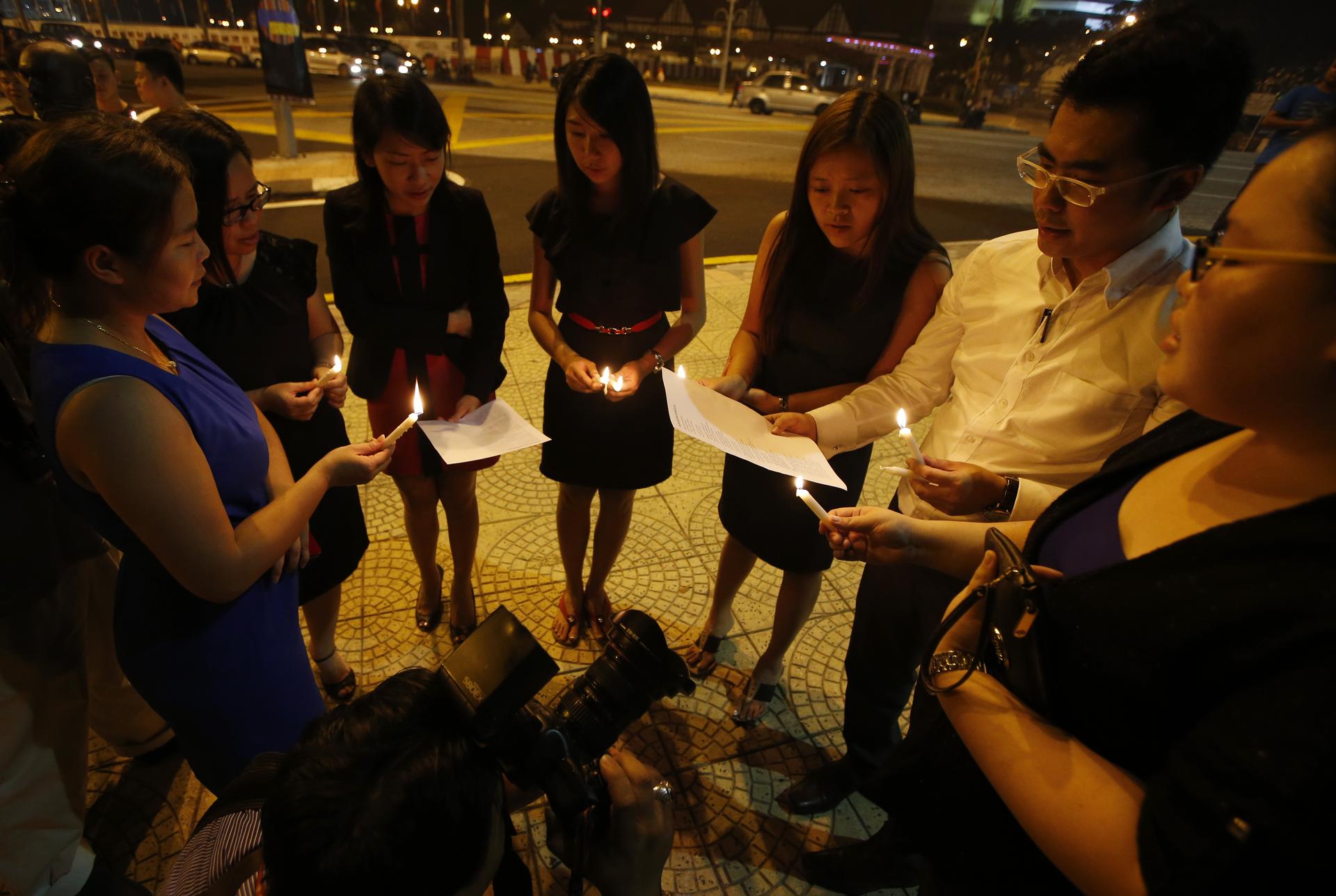 Malaysian ethnic Chinese sing songs as they hold a candlelight vigil for the passengers of Malaysia Airlines MH370 near Independence Square in Kuala Lumpur, Malaysia on March 10, 2014. 