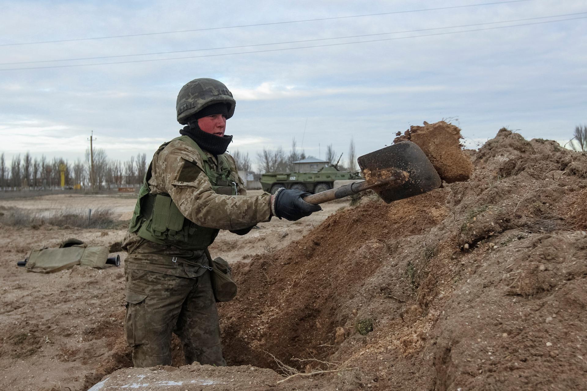 A Ukrainian serviceman digs a trench at a checkpoint facing Russian-occupied Crimea. Ukraine's small frontier detachments would have difficulty stopping an all-out Russian attack, but would more likely be by-passed and isolated, on the "Crimean model" of