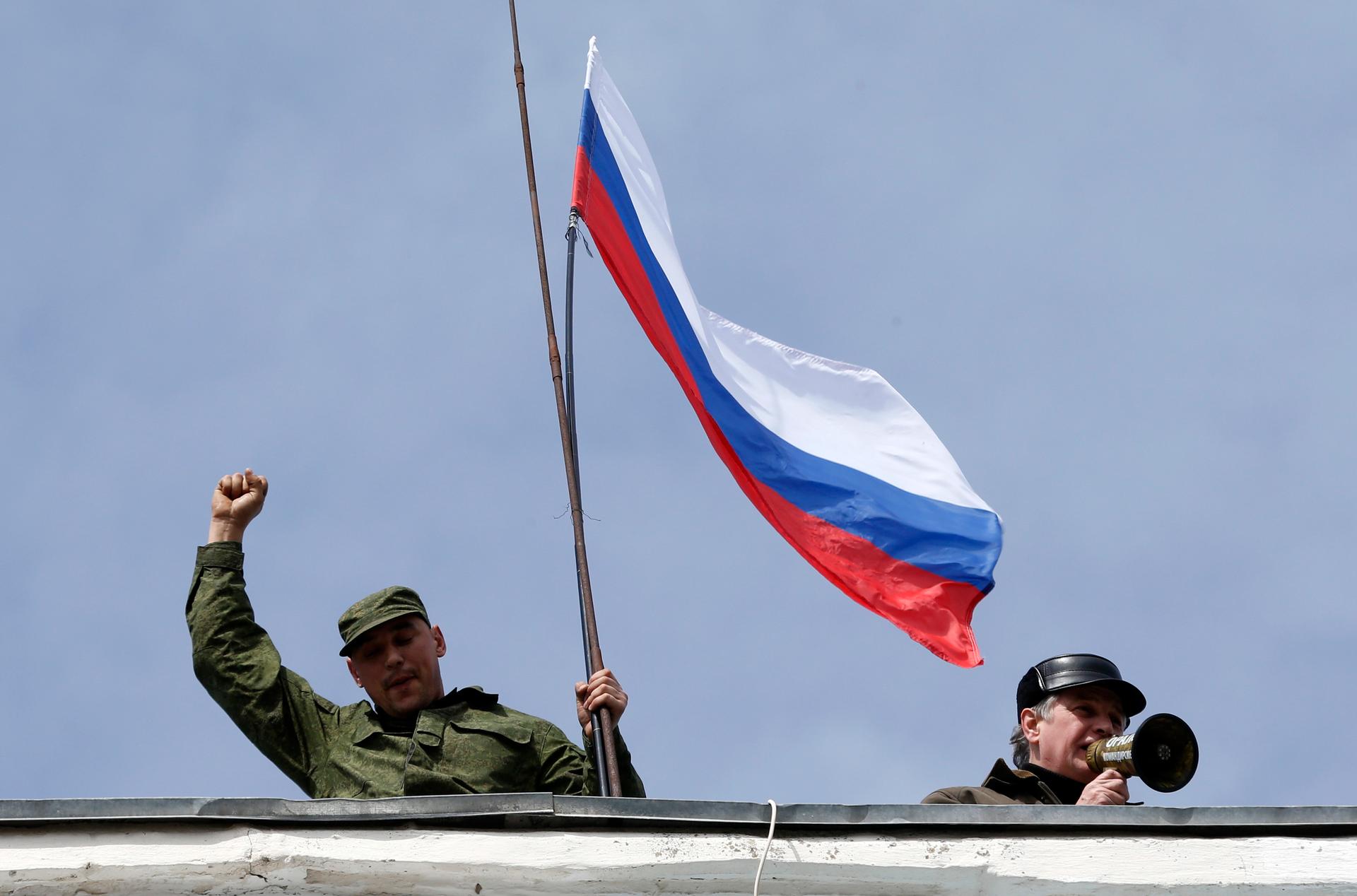 The Russian flag being hoisted over a Ukrainian naval facility in the Crimean city of Sevastopol, after the base was forcefully occupied, Wednesday.  