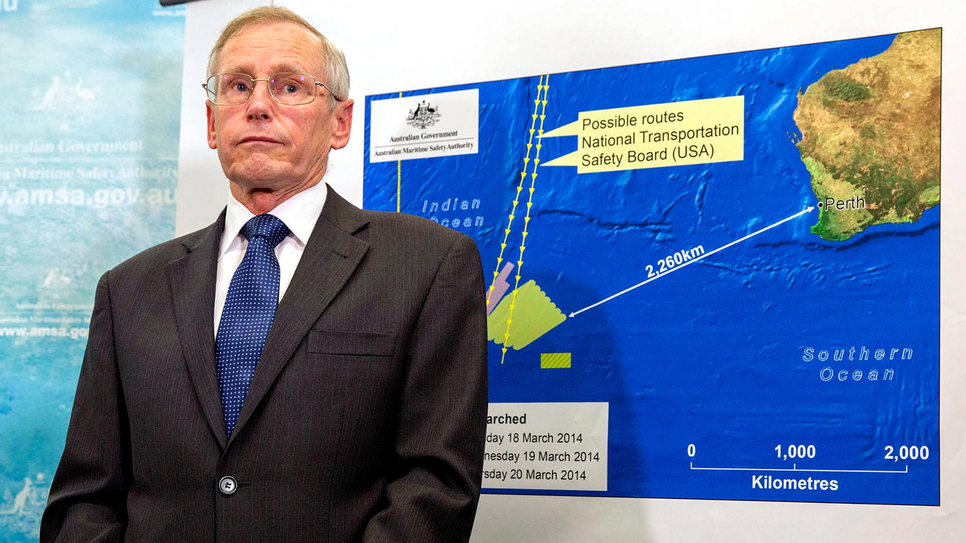 John Young, general manager of the emergency response division of the Australian Maritime Safety Authority (AMSA), stands in front of a diagram showing the search area for Malaysia Airlines Flight MH370 in the southern Indian Ocean, during a briefing in C