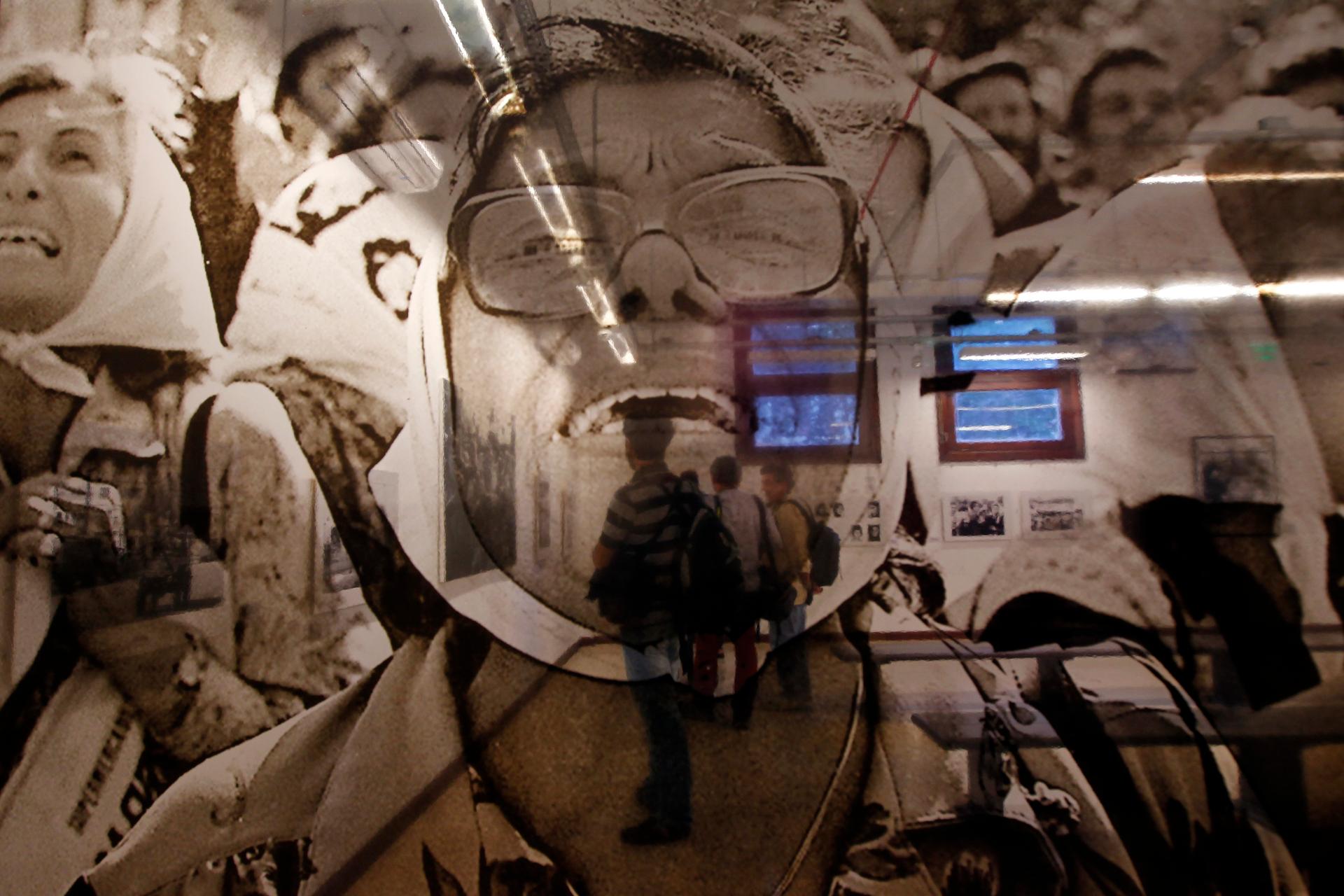 People are seen through a photograph by Argentine photographer Daniel Garcia at a photo exhibition about human rights organization Abuelas de Plaza de Mayo (Grandmothers of Plaza de Mayo), March 24, 2014.