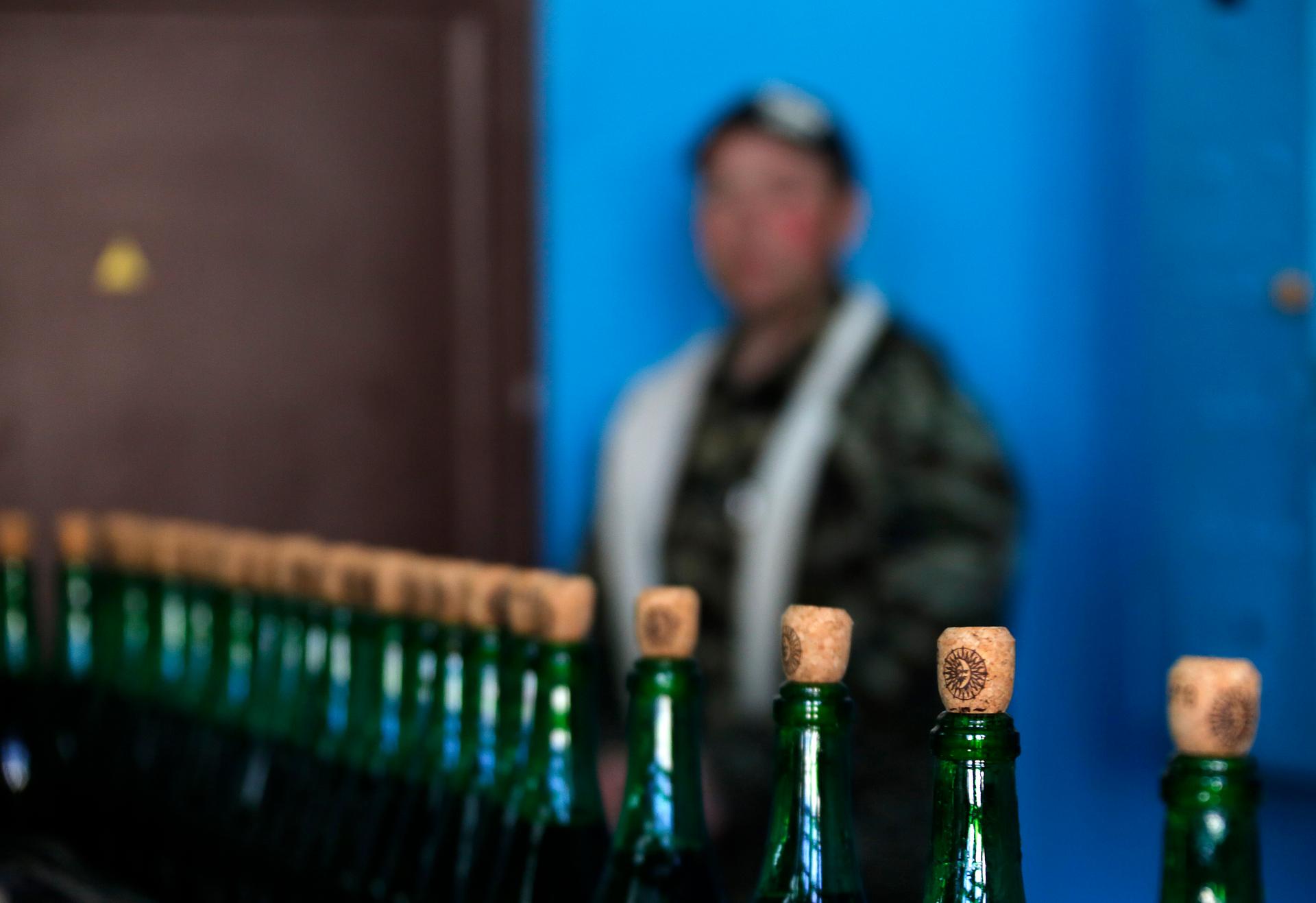 A worker watches a production line of sparkling wine in a coastal Crimean village.