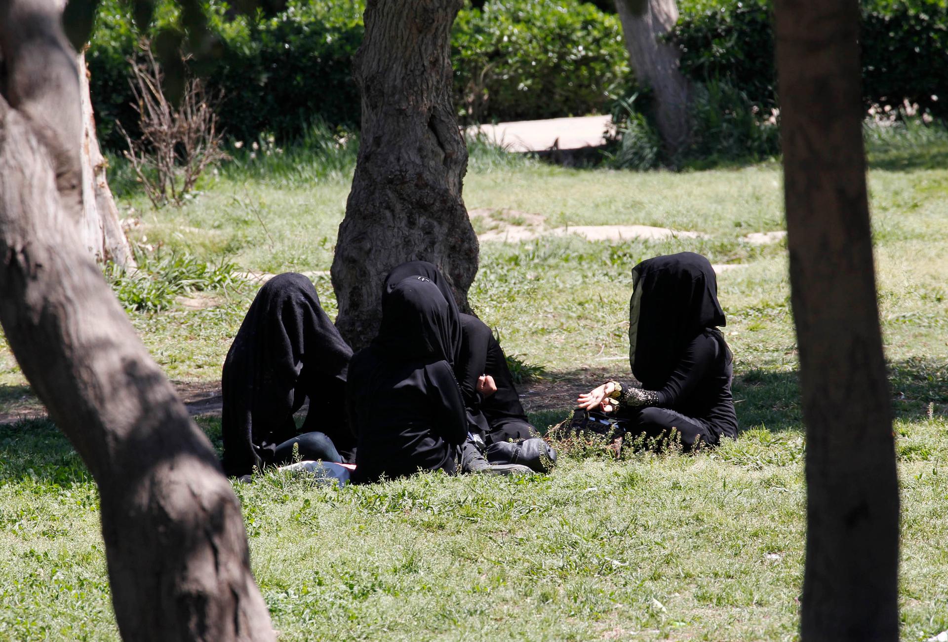 Veiled women sit as they chat in a garden in the ISIS-controlled province of Raqqa in northern Syria.