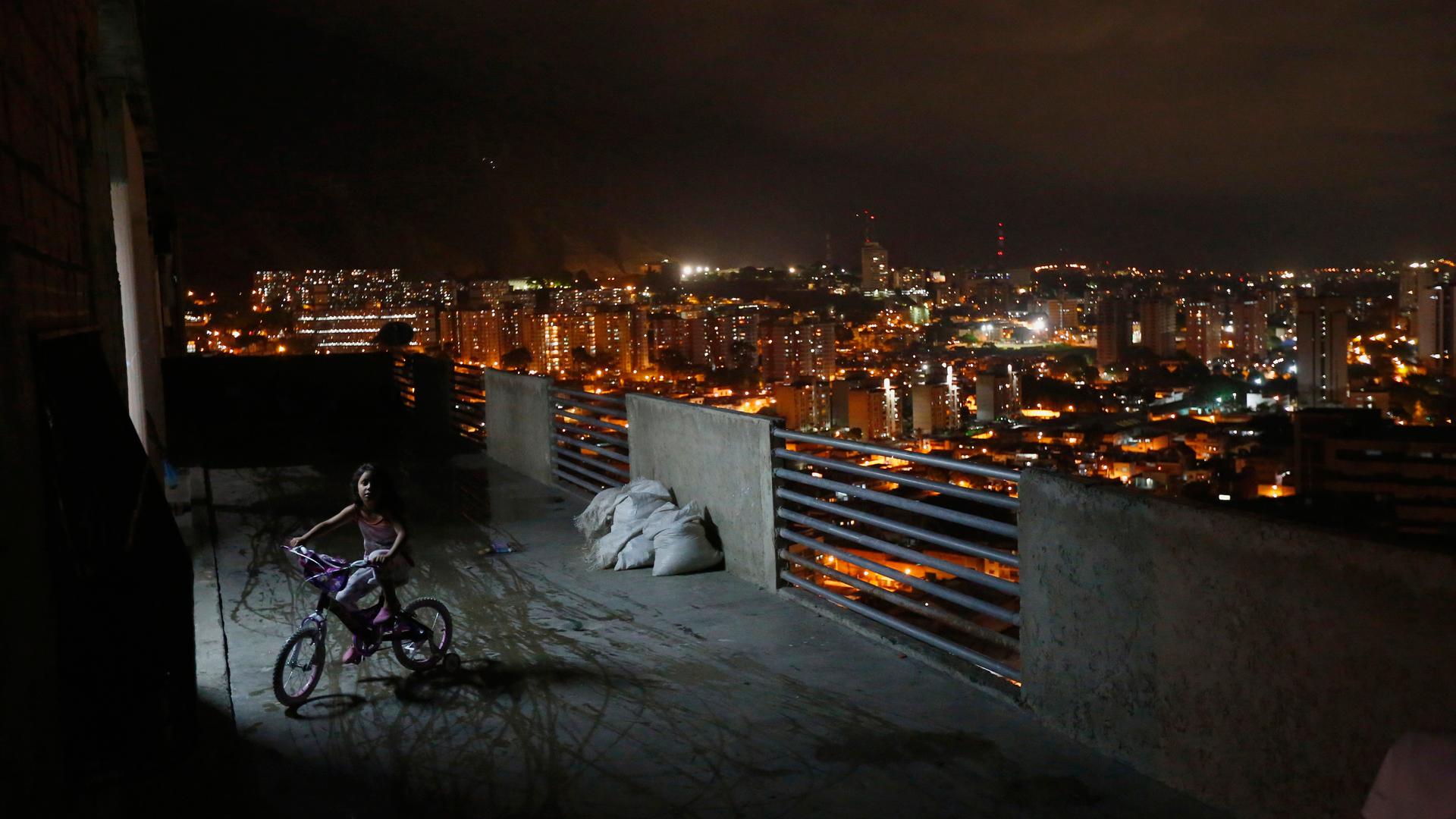 A girl rides a bicycle on a balcony in the "Tower of David" skyscraper.