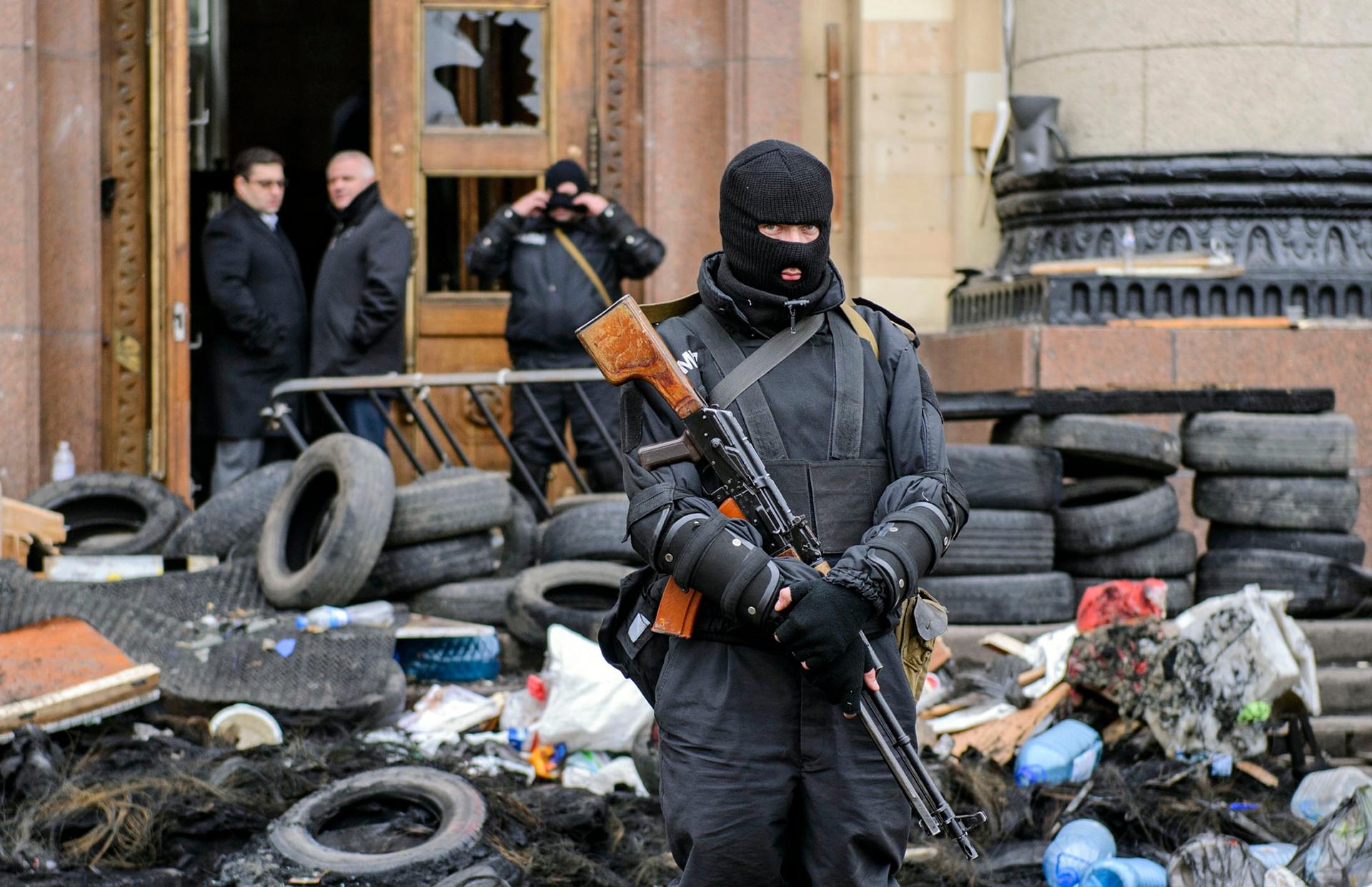 A masked armed man, representing Ukrainian special forces, stands guard outside the regional administration building in Kharkiv, April 8, 2014. 