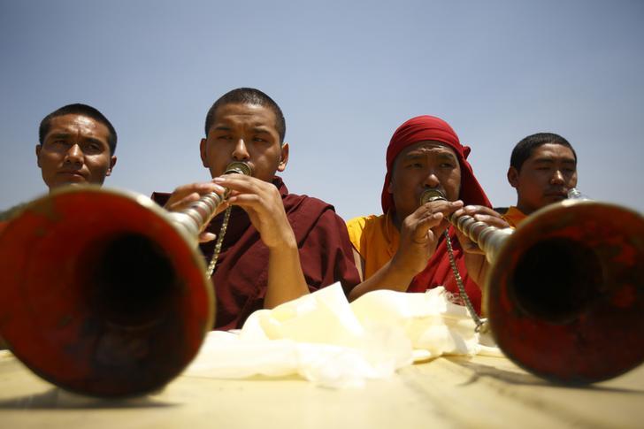 Buddhist monks offer prayer during the funeral rally of Nepali Sherpa climbers in Kathmandu April 21, 2014. Nepal's Sherpas have demanded compensation of $10,000 for the families of 16 colleagues dead or missing in an avalanche on Mount Everest and double