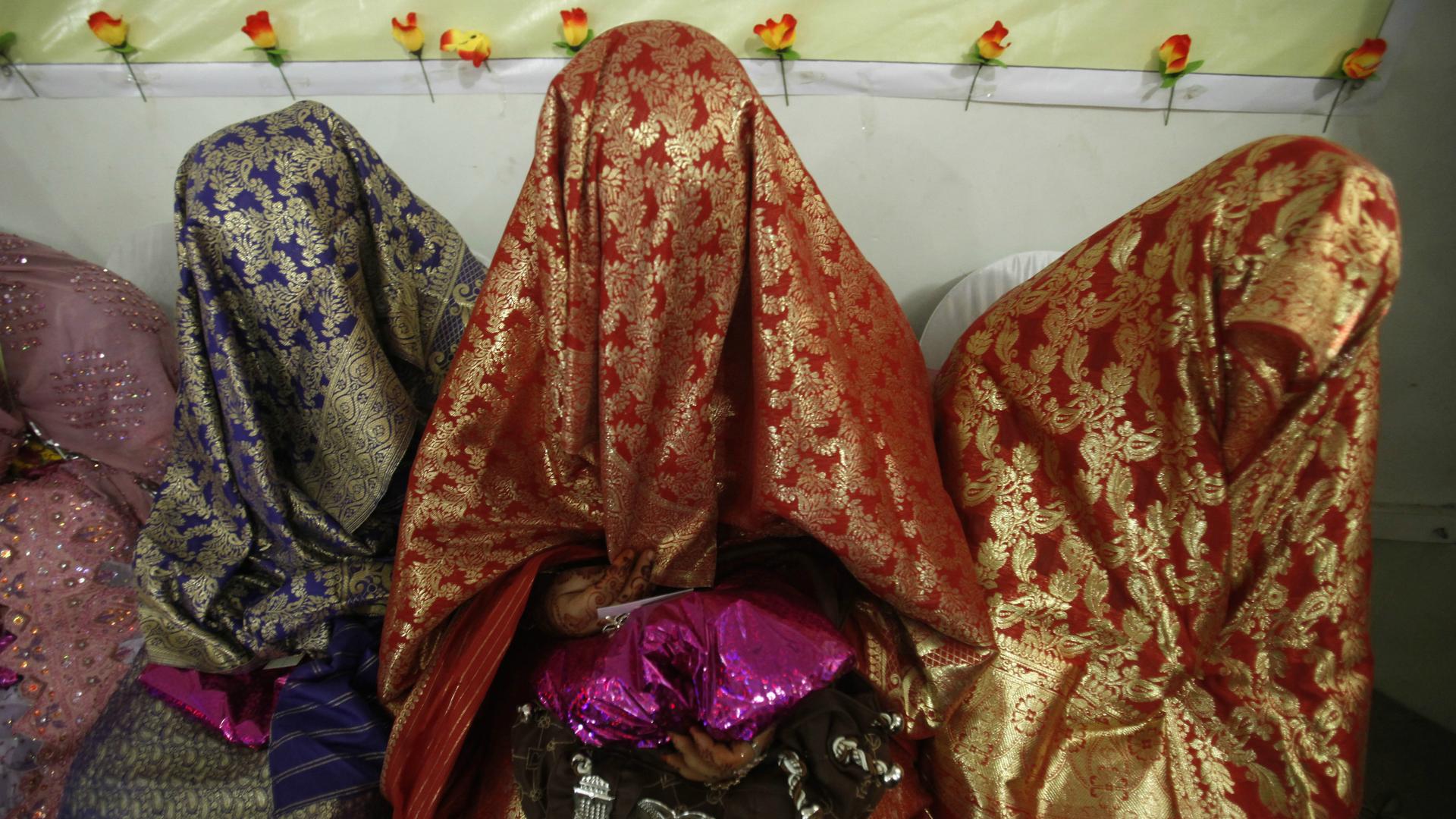 Brides sit together during a mass wedding ceremony in Peshawar, Pakistan, April 25, 2014.