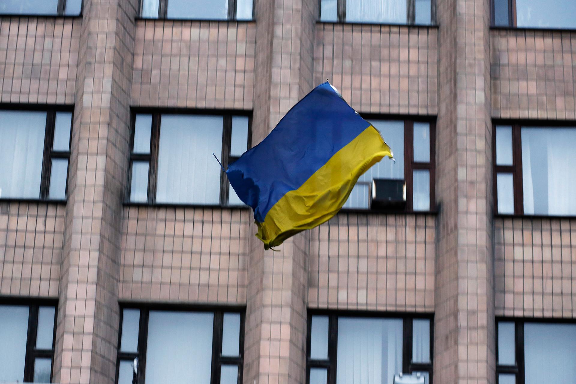 A Ukrainian flag tumbles to the street, after being thrown by pro-Russian protesters from the top of a district council building in Ukraine. 