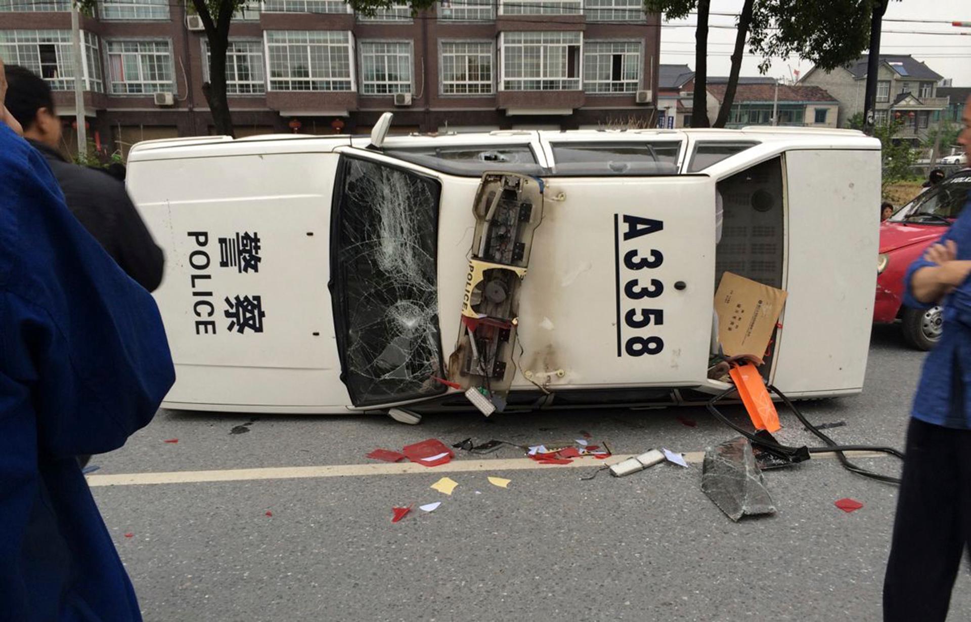 A police car is seen smashed and overturned as demonstrators protest against the construction of a waste incinerator in Hangzhou, China.