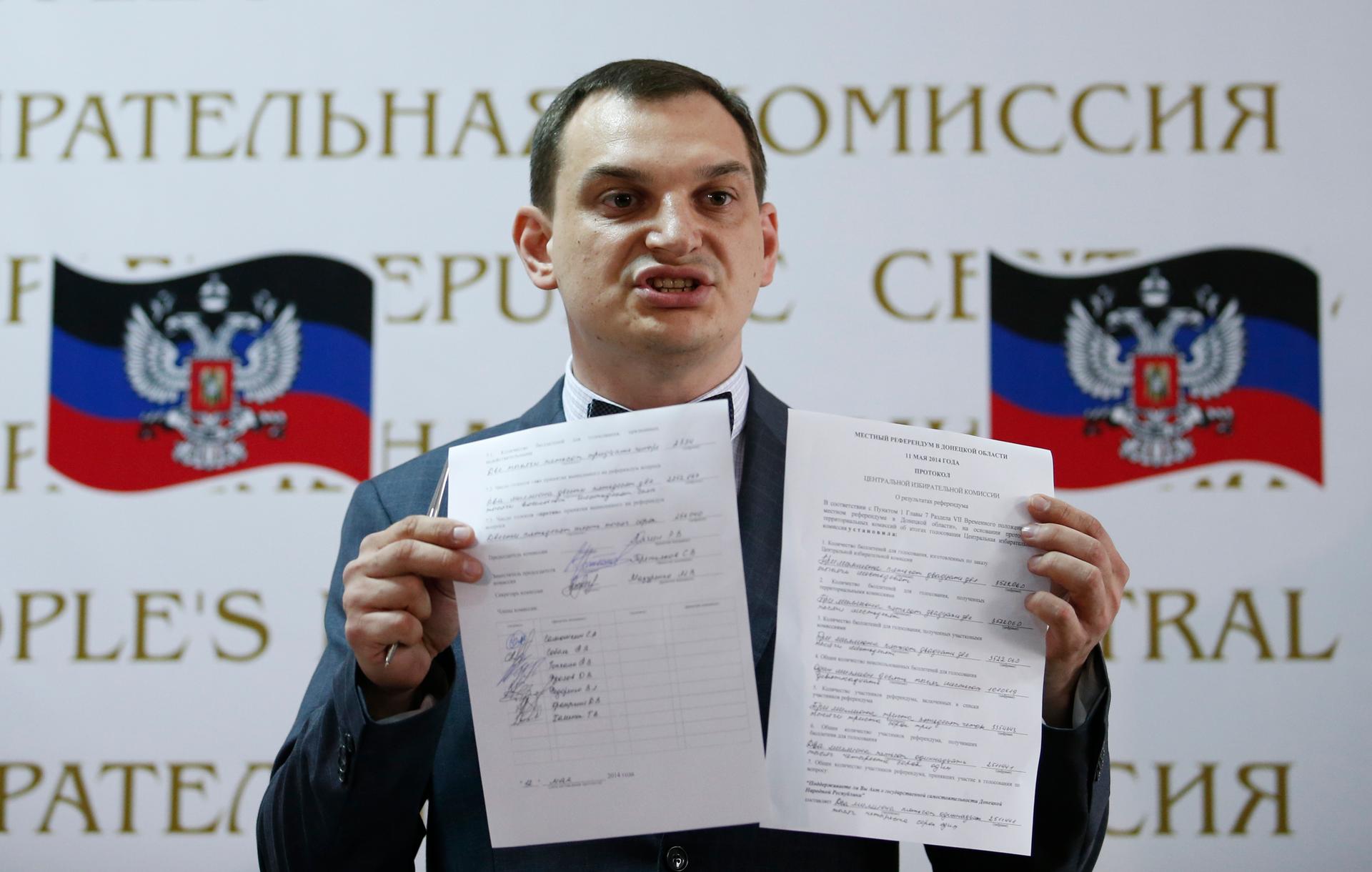 Roman Lyagin, head of the electoral commission in Donetsk, holds up the results of the referendum on the status of the province, during a news conference Monday. Pro-Russian separatists say they received overwhelming support.