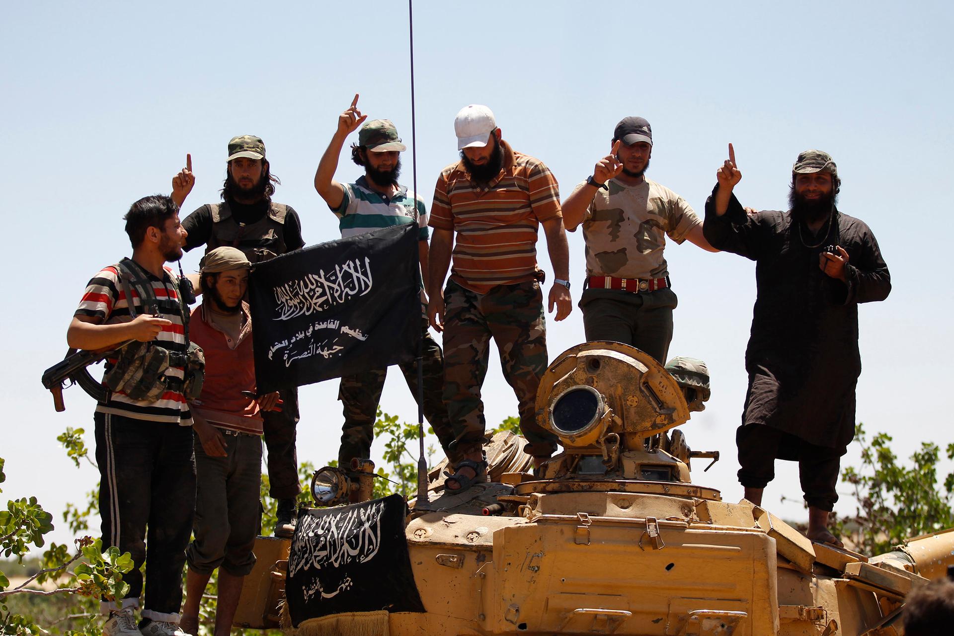 Members of the Islamist Syrian rebel group, Jabhat al-Nusra, pose on top a tank in northern Syria earlier this year. 