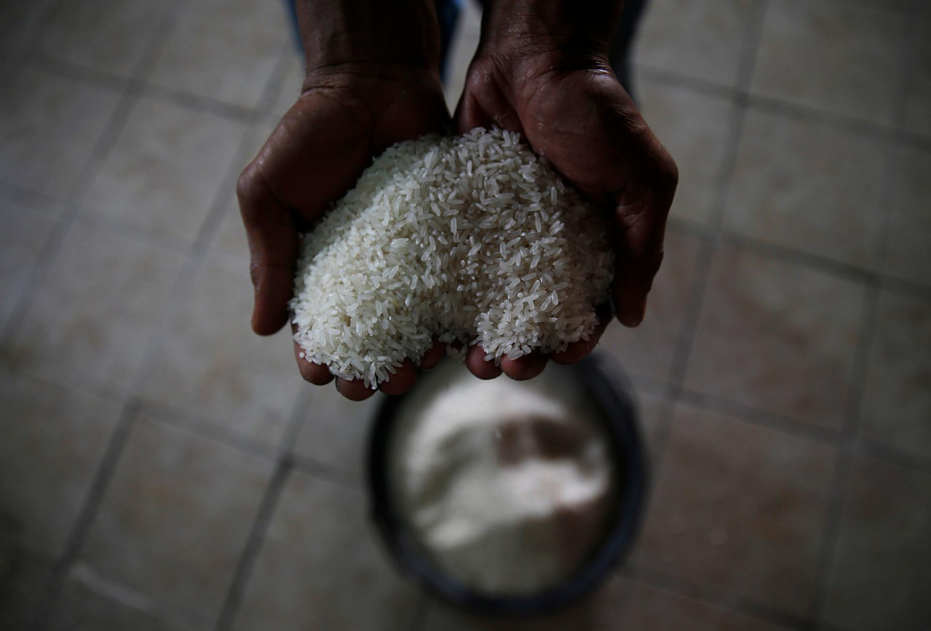 A worker holds rice at a rice mill during harvest time in Padalarang, Indonesia's West Java province, May 27, 2014.