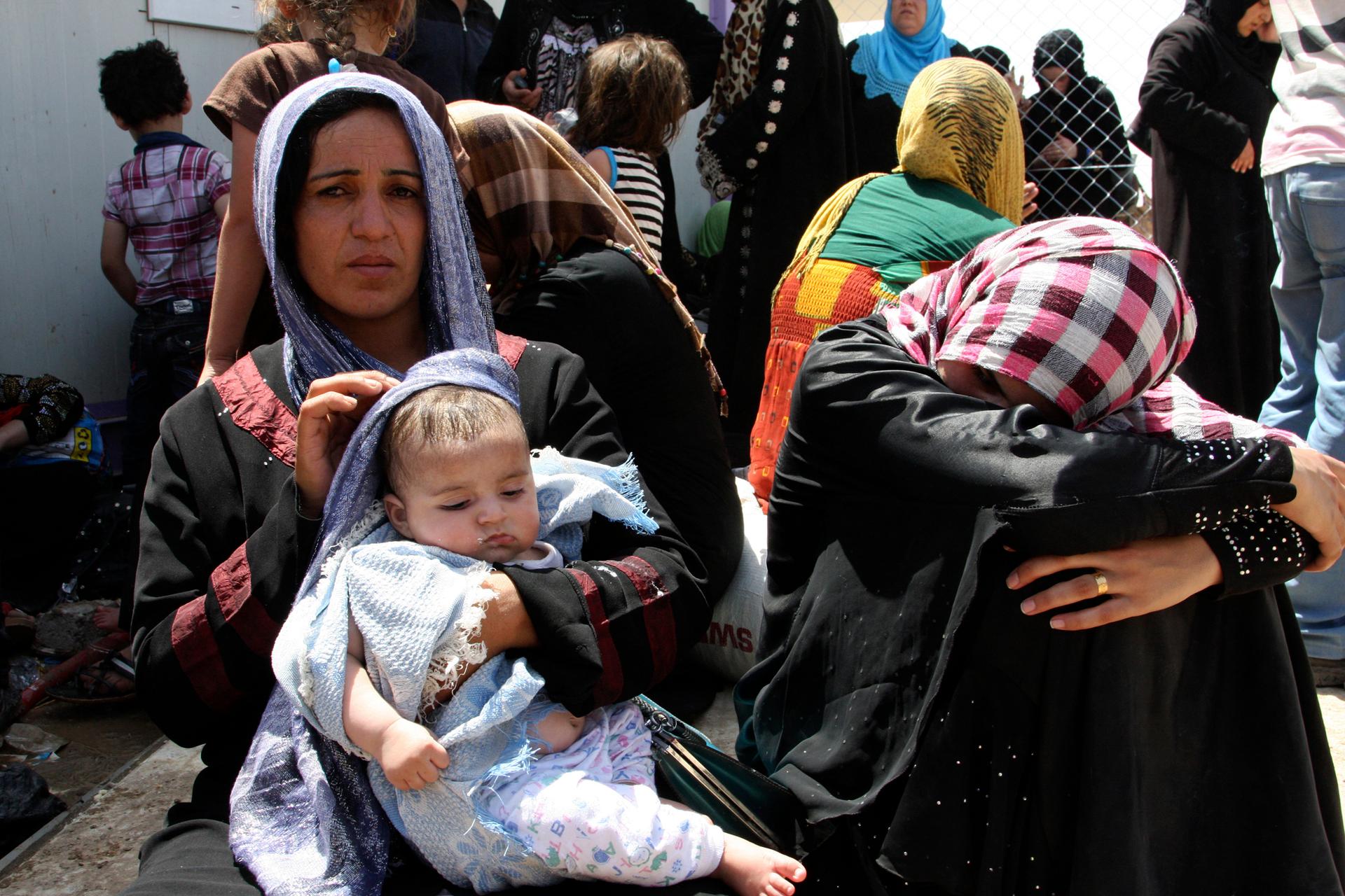 Families fleeing the violence in Mosul wait at a checkpoint on the outskirts of Arbil, in Iraq's Kurdistan region on June 10, 2014. Radical Sunni Muslim insurgents seized control of most of Iraq's second largest city of Mosul early on Tuesday, overrunning