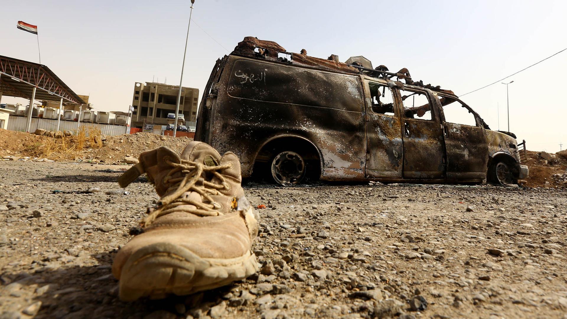 A burnt vehicle belonging to Iraqi security forces is pictured at a checkpoint in east Mosul on June 11, 2014, one day after radical Sunni Muslim insurgents seized control of the city.