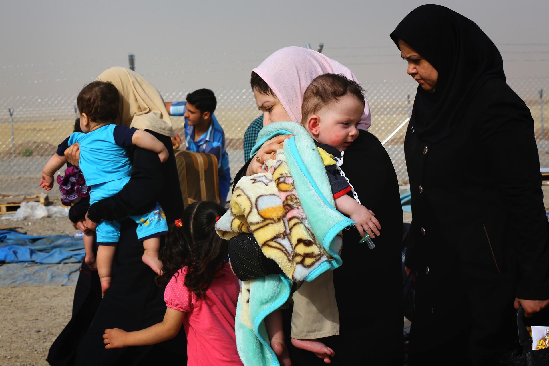 Families fleeing the violence in the Iraqi city of Mosul arrive at a checkpoint on the outskirts of Arbil.