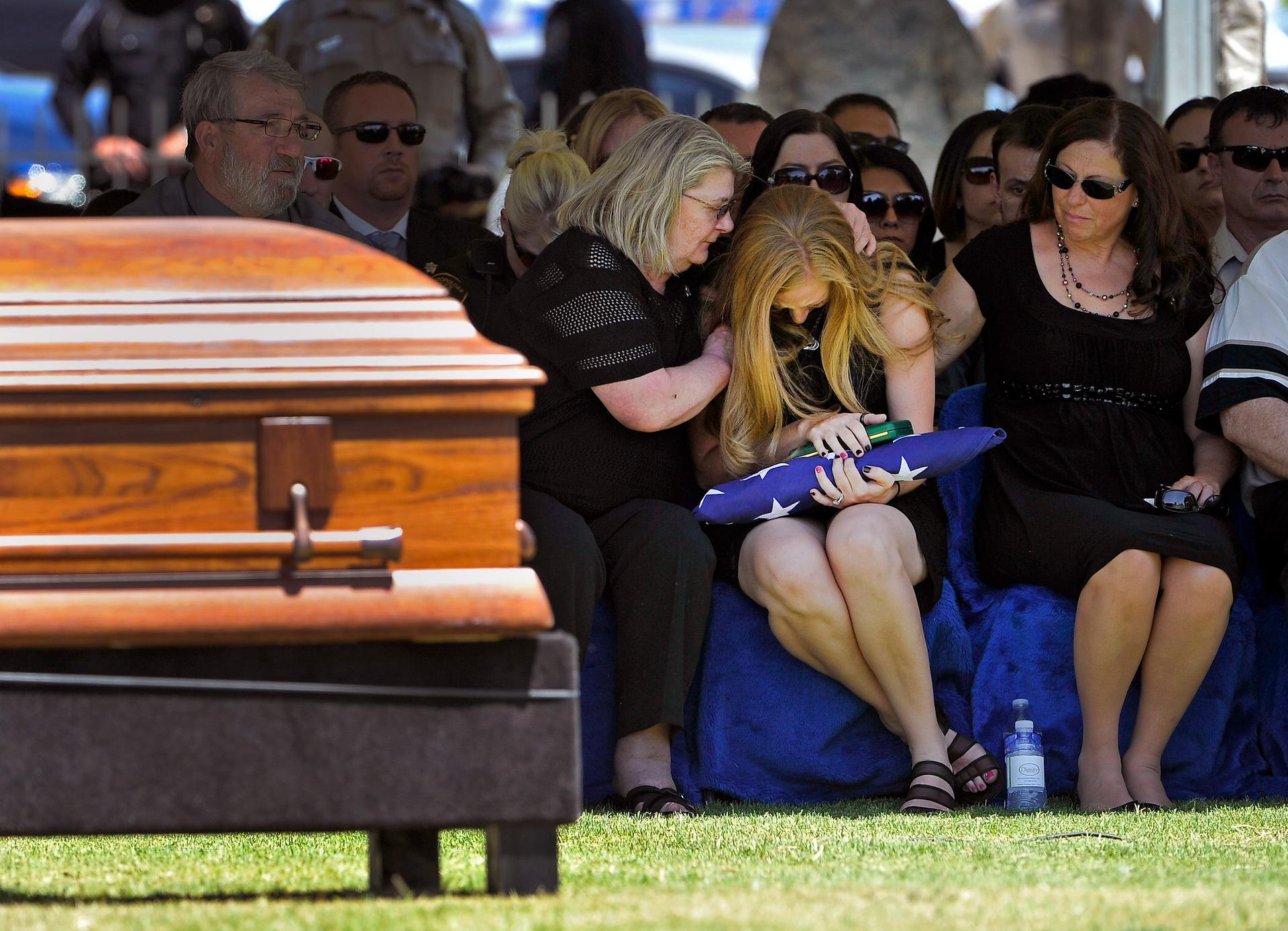 Andrea Soldo is consoled by family members after receiving a flag during the funeral services for her husband, Las Vegas police officer Igor Soldo, in Las Vegas, Nevada, on June 12, 2014.