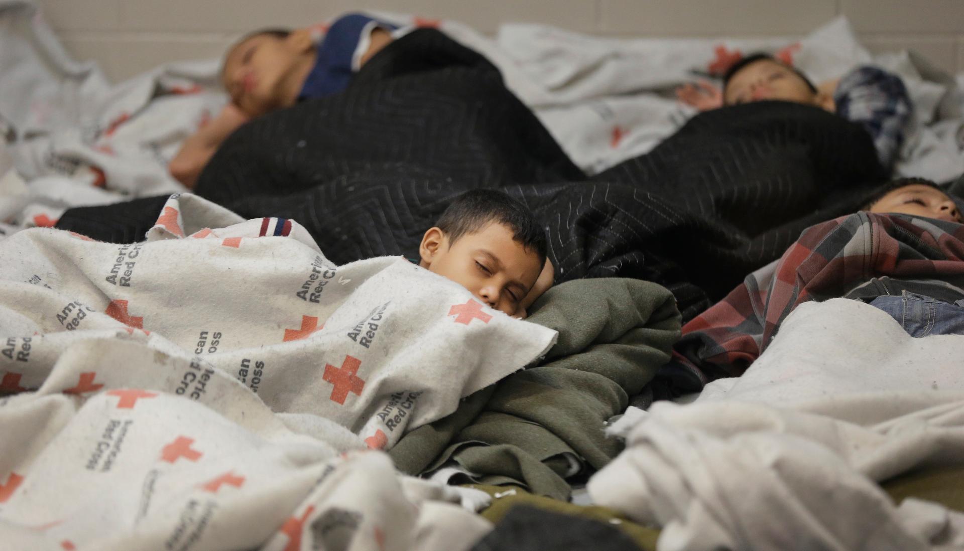 Detainees sleep in a holding cell at a US Customs and Border Protection processing facility, in Brownsville, Texas on June 18, 2014.