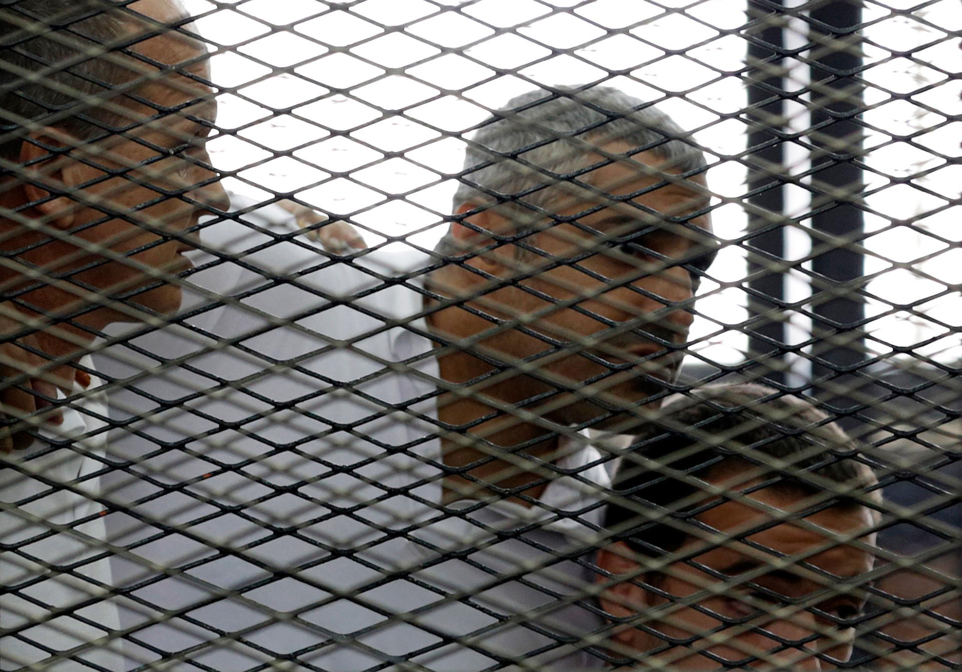 Peter Greste, Mohamed Fahmy and Baher Mohamed (L to R) listen to a ruling at a court in Cairo June 23, 2014. The three Al Jazeera journalists were jailed for seven years in Egypt on Monday after the court convicted them of helping a "terrorist organizatio