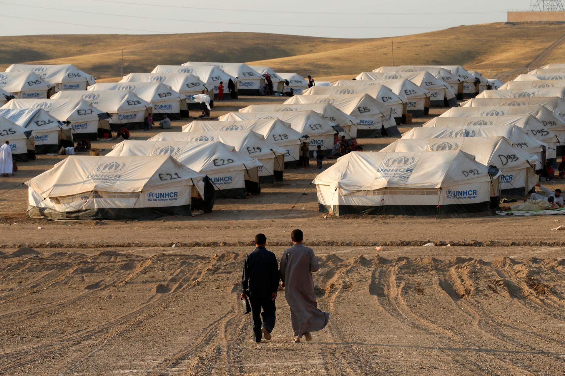 Iraqi refugees, who fled from the violence in Mosul, walk inside the Khazer refugee camp on the outskirts of Arbil, in Iraq's Kurdistan region, June 27, 2014.