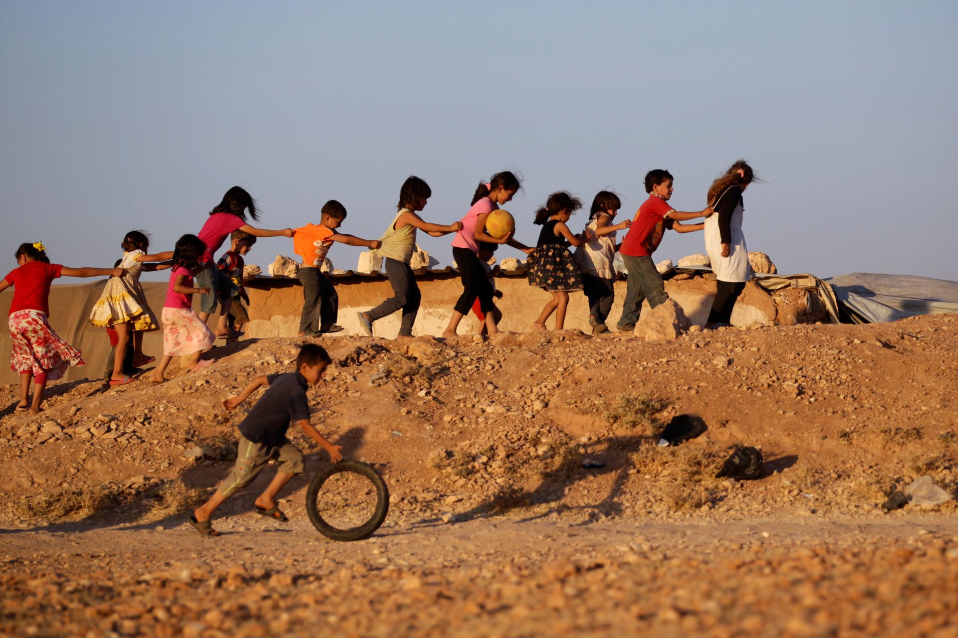 Children, who are internally displaced due to the fighting between rebels and the forces of Syrian President Bashar al-Assad, play inside Al-Tah camp in the southern Idlib countryside July 4, 2014.