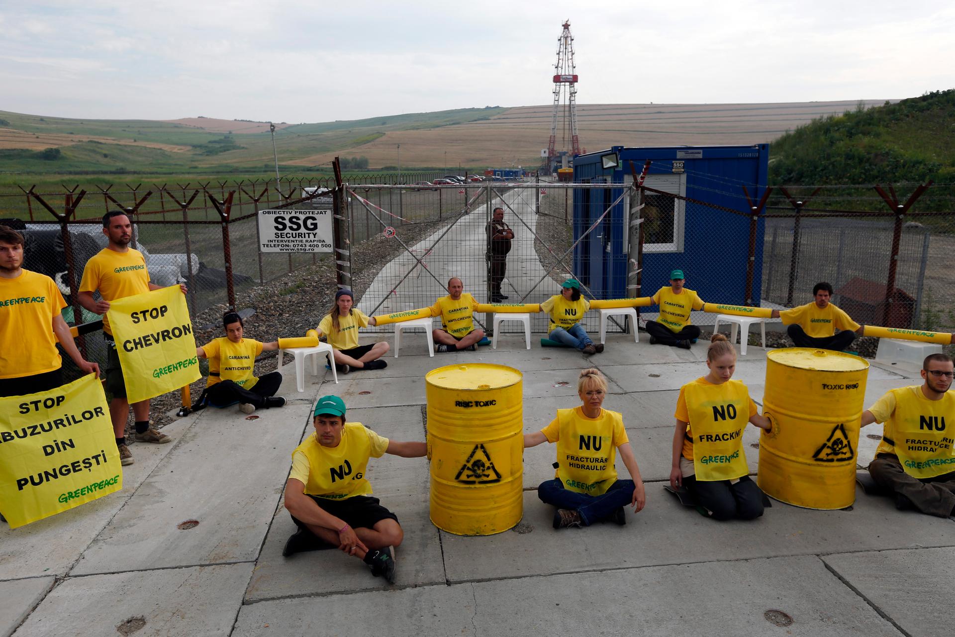 Greenpeace activists sit chained in front of Chevron's drilling site for shale gas during a protest in the village of Pungesti, Romania.