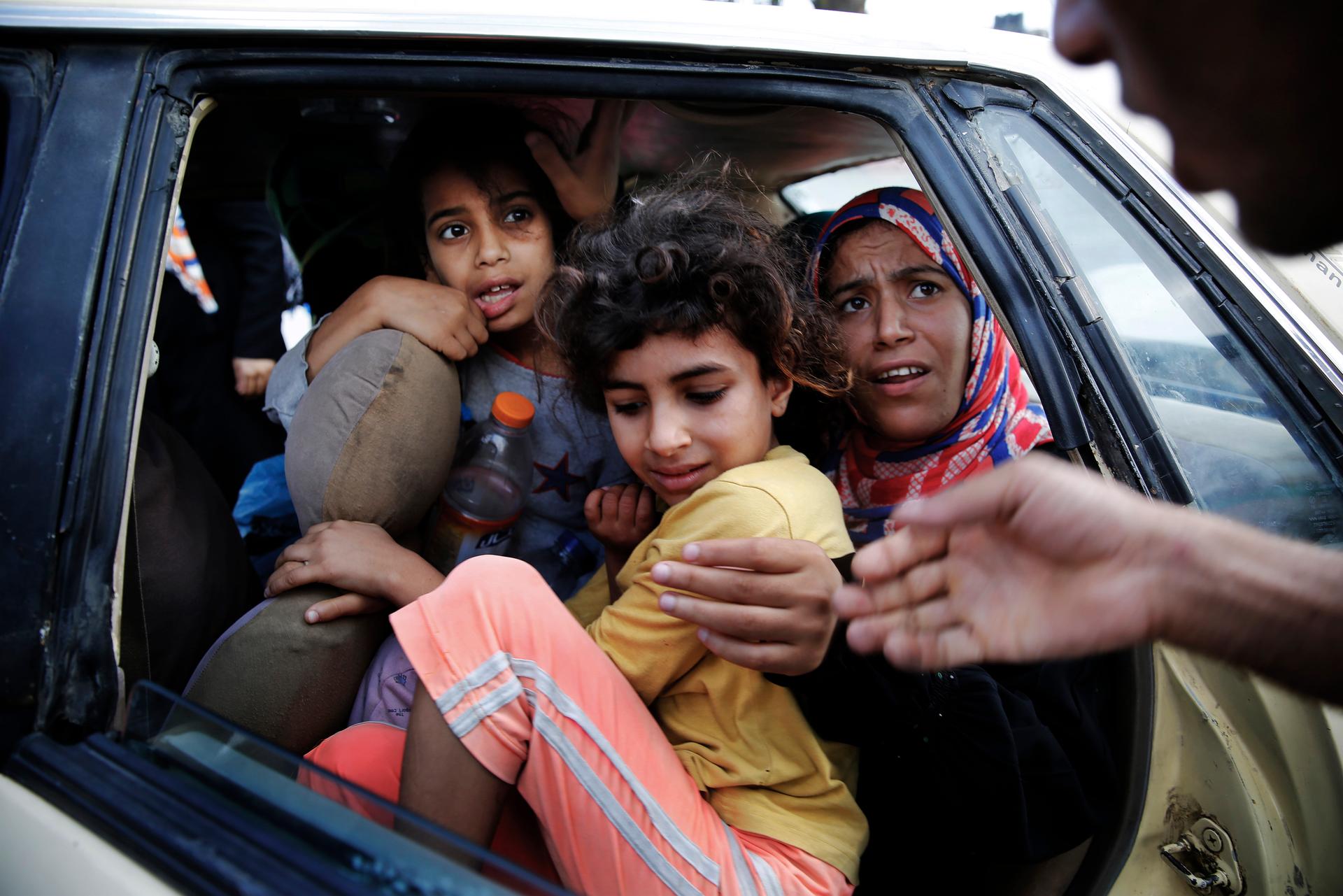 Palestinians fled in a vehicle Monday from Israeli shelling in Bet Lahiya in northern Gaza Strip.
