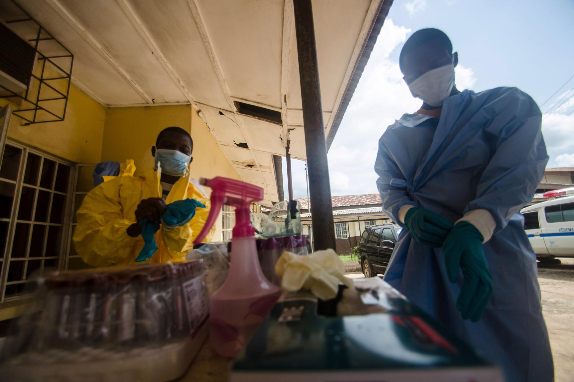 Medical staff put on protective gear in the Kenema government hospital before taking a sample from a suspected Ebola patient in Kenema, Sierra Leone.