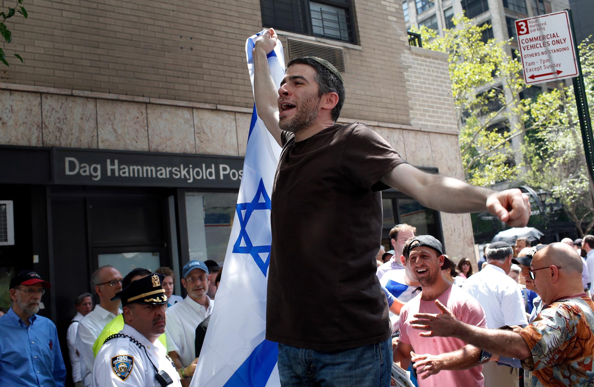 A man holds up an Israeli flag during a pro-Israel demonstration near the United Nations building in New York City, July 28, 2014. 