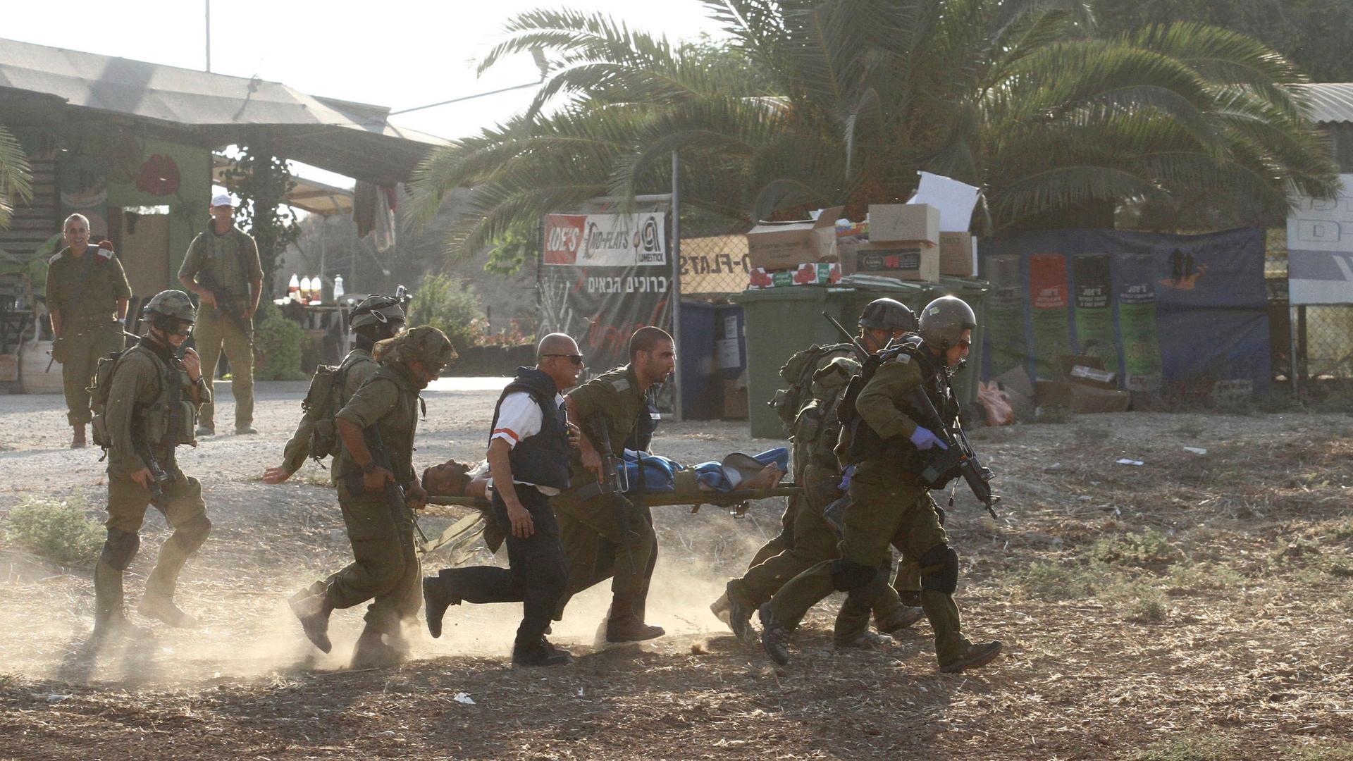 Israeli soldiers evacuate a comrade after he was wounded in a Palestinian mortar strike inside Israel on Monday.