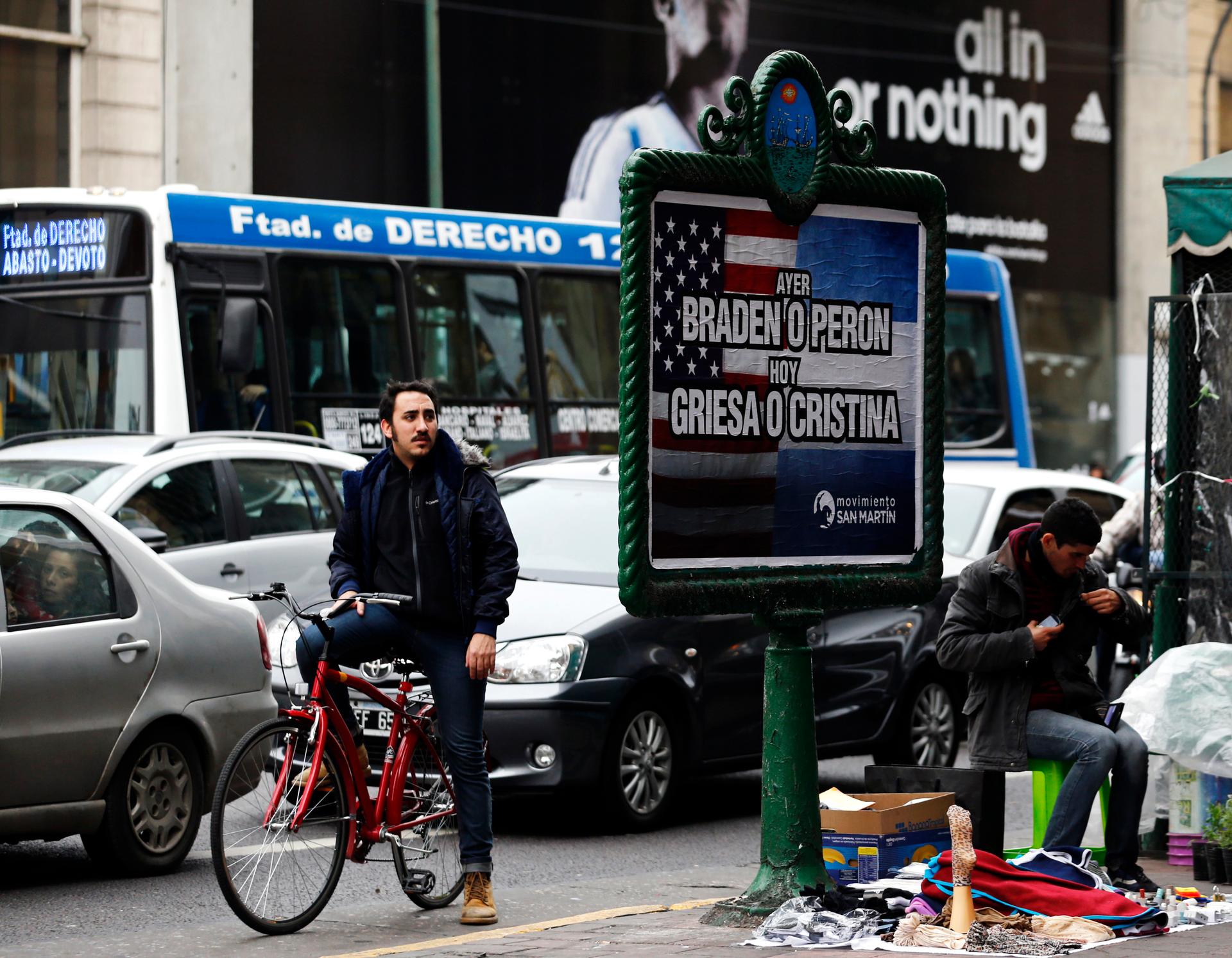 A man looks at a poster placed on an advertising board that reads "Yesterday, Braden or Peron - Today: Griesa or Cristina", in Buenos Aires on July 29, 2014. Argentine debt negotiators held talks in New York on Tuesday with the U.S. mediator in the South 
