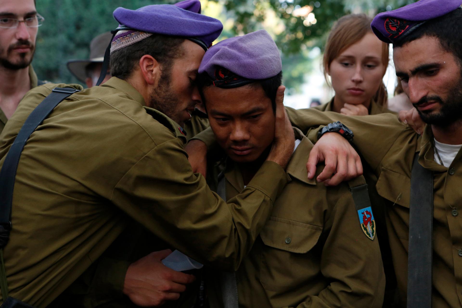 Israeli soldiers mourn during the funeral of their comrade Lieutenant Hadar Goldin in Kfar Saba, near Tel Aviv, on August 3, 2014. Goldin's death in Gaza is prompting some in Israel to question their military's controversial Hannibal Doctrine.