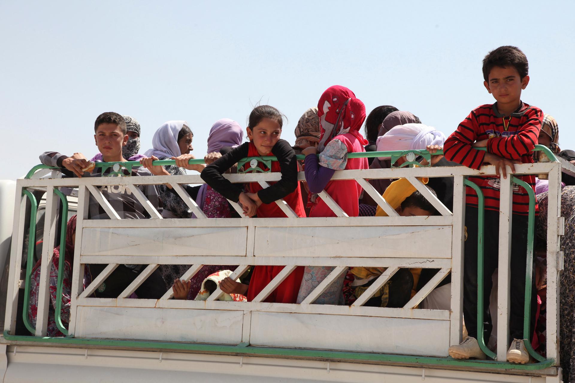 Displaced families from the minority Yazidi sect flee violence in the northern Iraqi town of Sinjar. Iraq's Prime Minister, Nuri al-Malik, ordered his air force for the first time to back Kurdish forces against Islamic State fighters after the Sunni milit